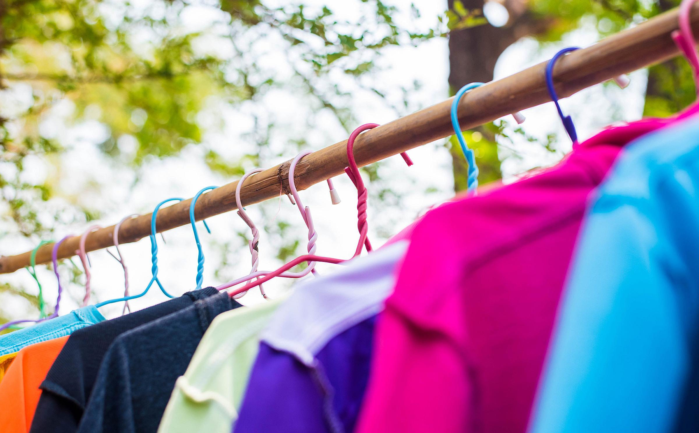 Clothing on hangers with trees behind them