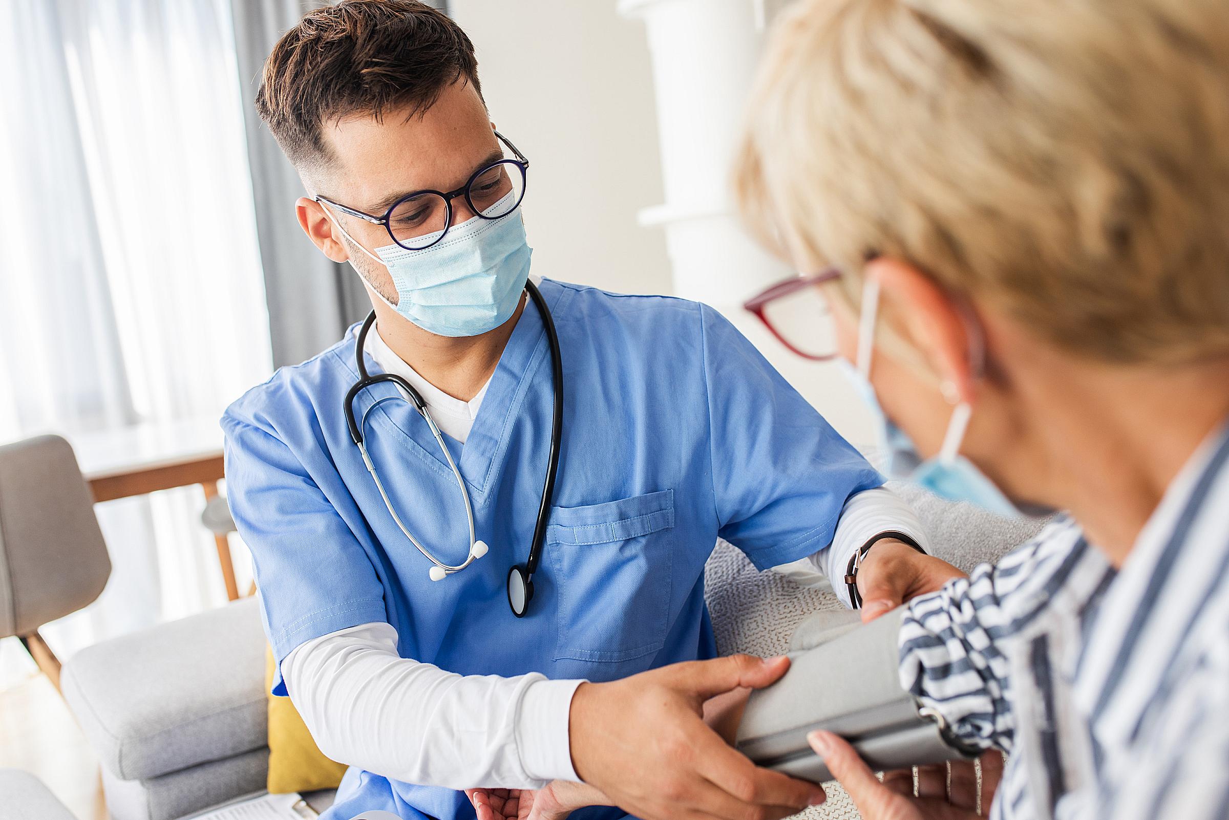 Male nurse takes patient's blood pressure