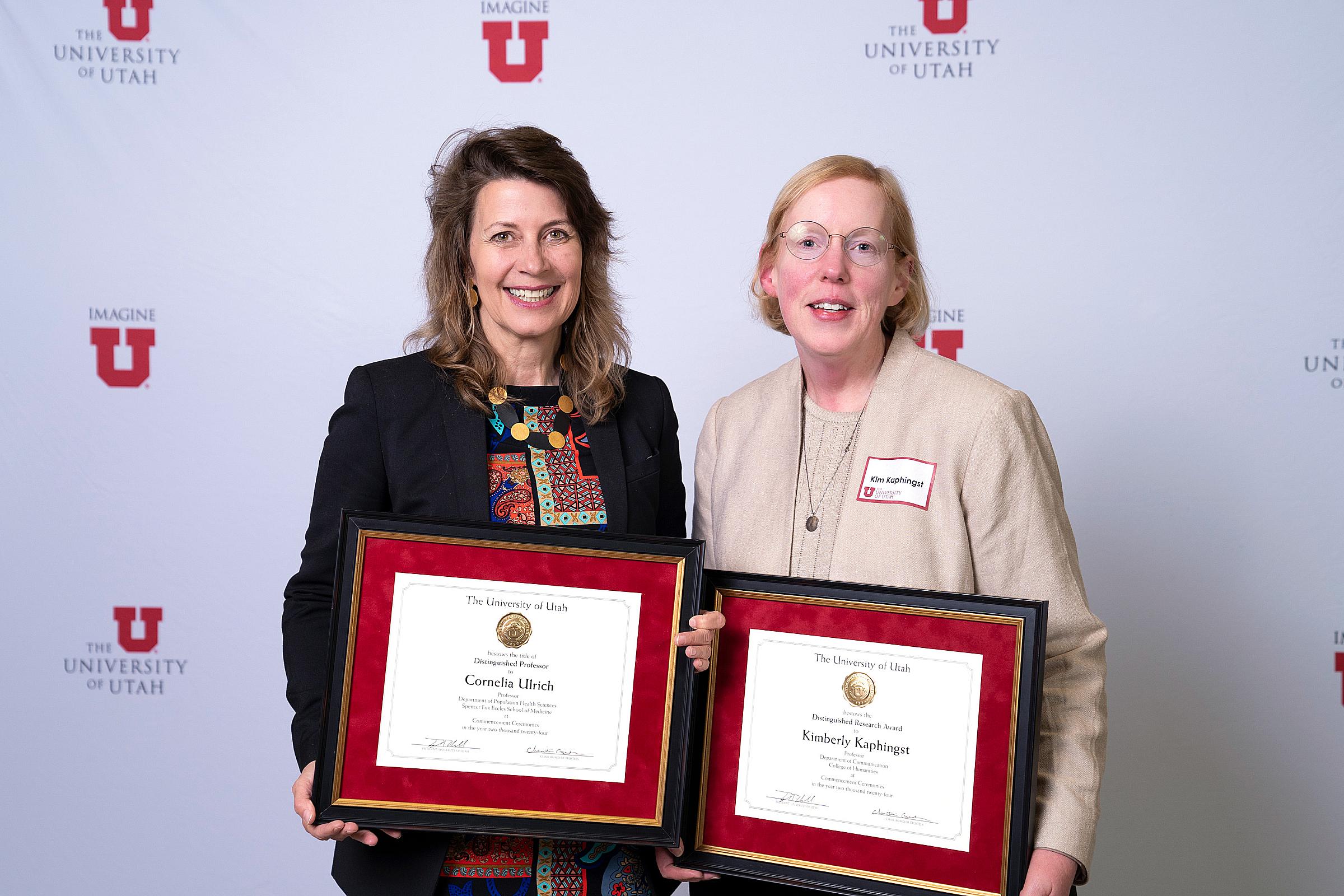 Neli Ulrich, PhD, MS, and Kim Kaphingst, ScD, holding their award plaques at the 2024 Faculty Awards