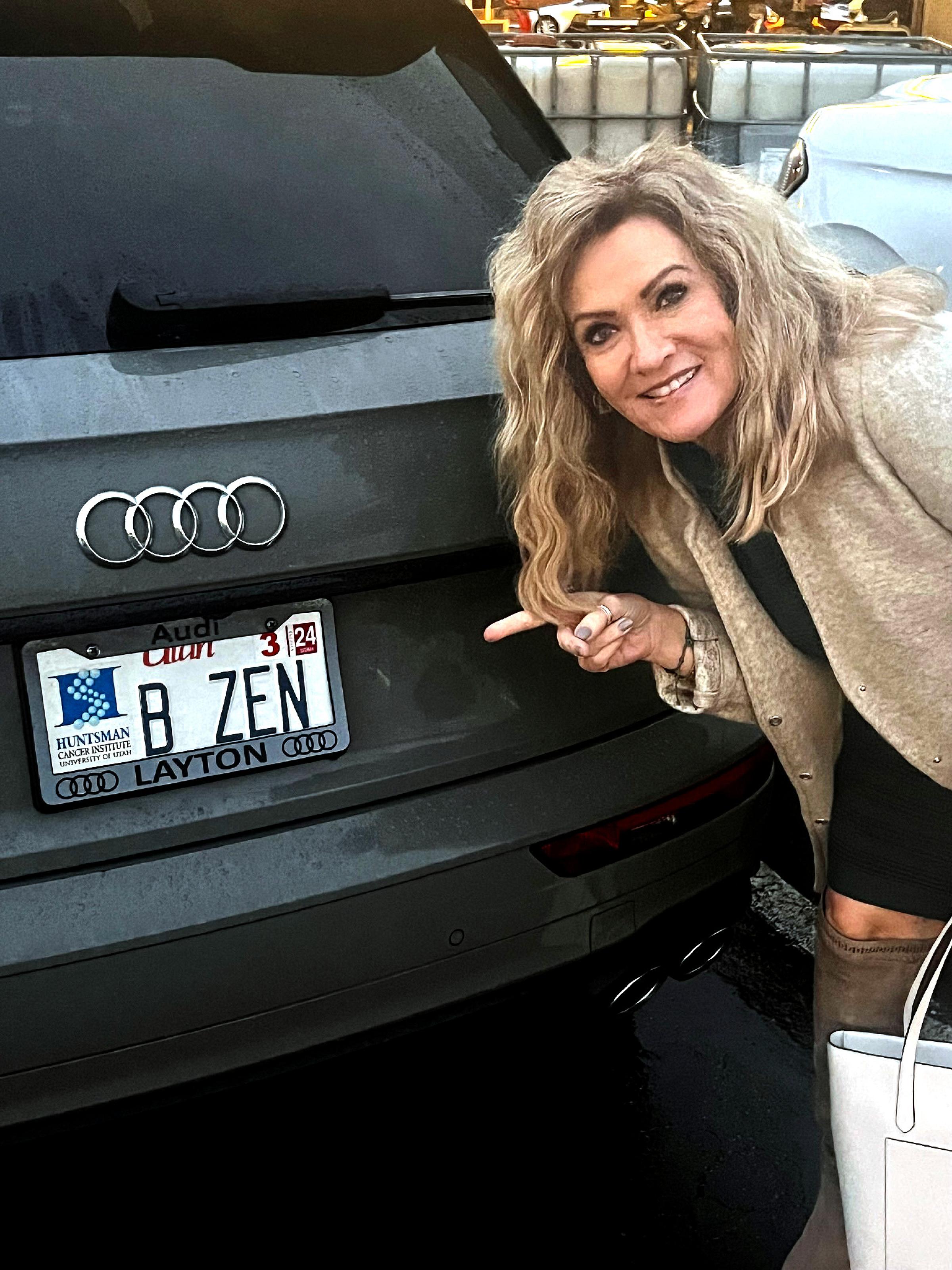 Ruth Hill pointing at her vanity license plate: B Zen
