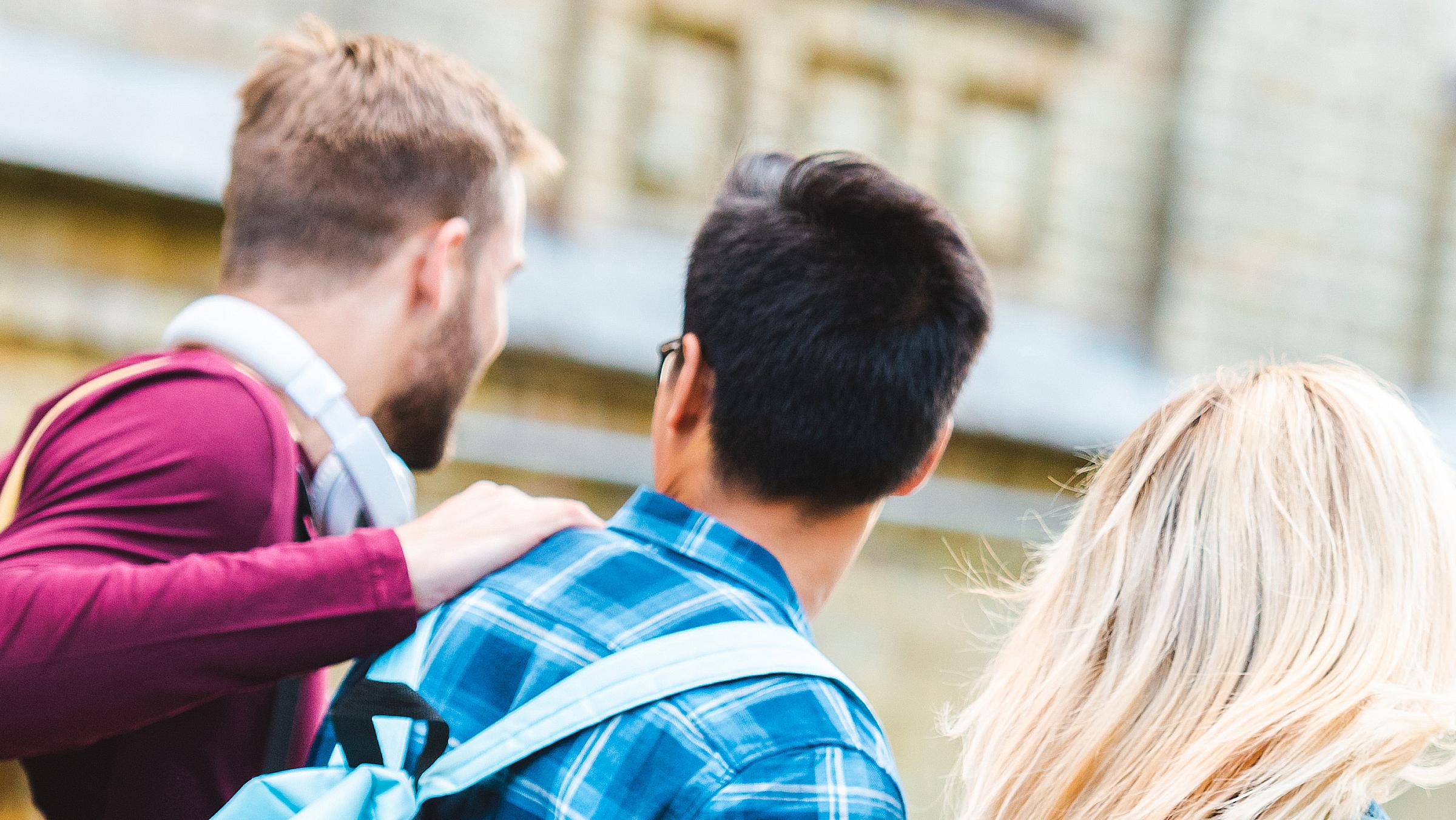 Back view of group of young adults walking together