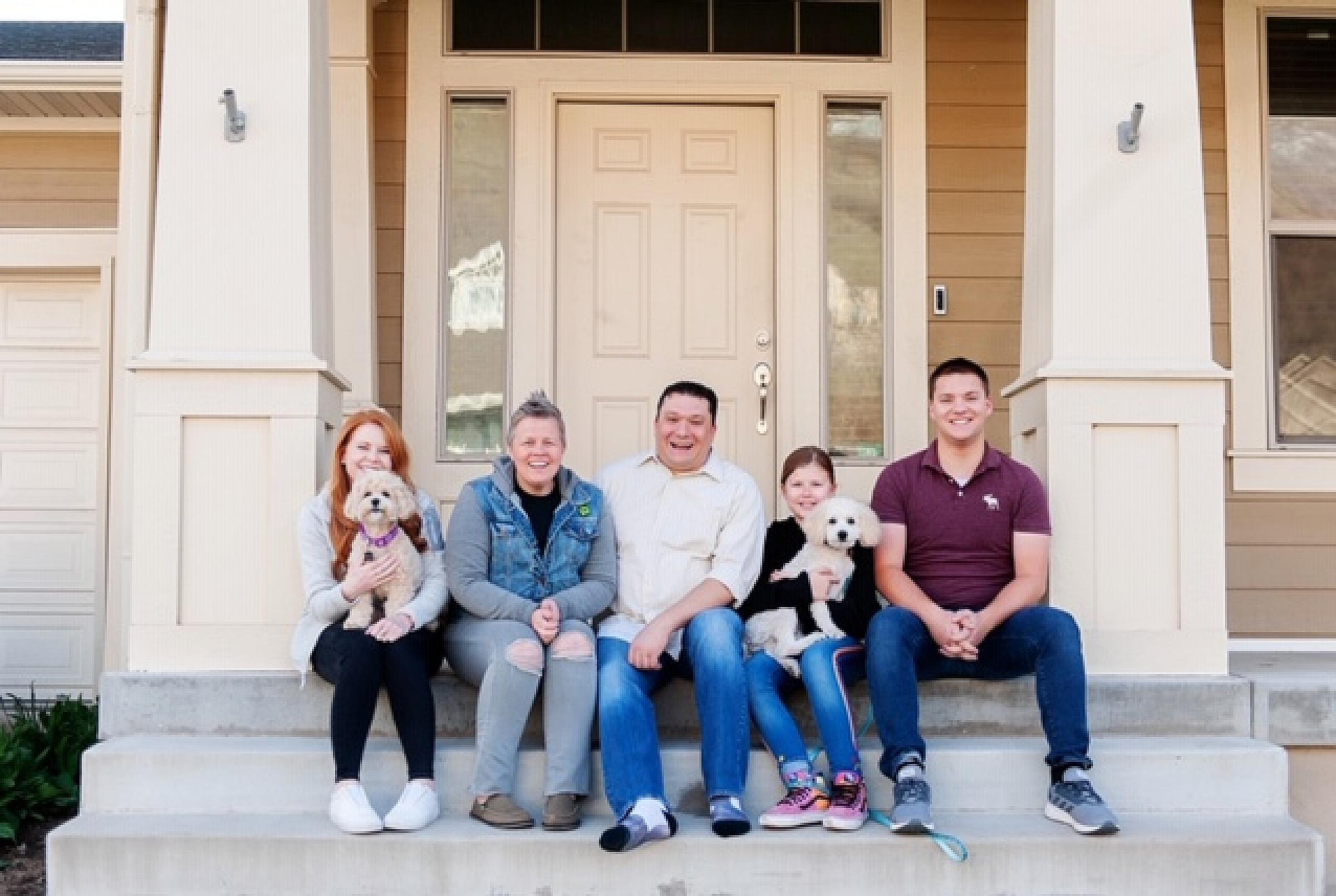 Candis Shupe and her family sitting on the steps of their house