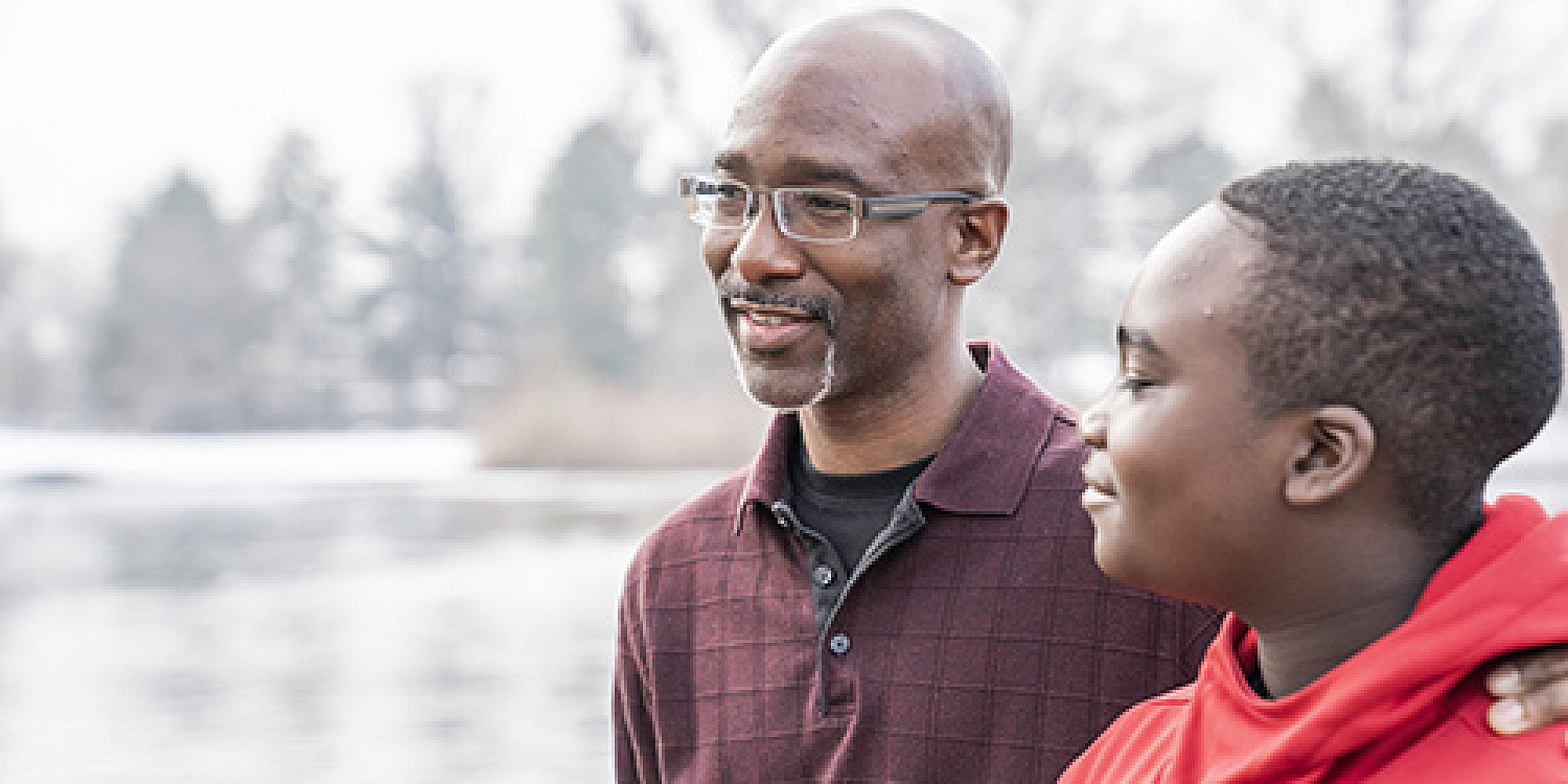 Father and son looking out at a lake and smiling