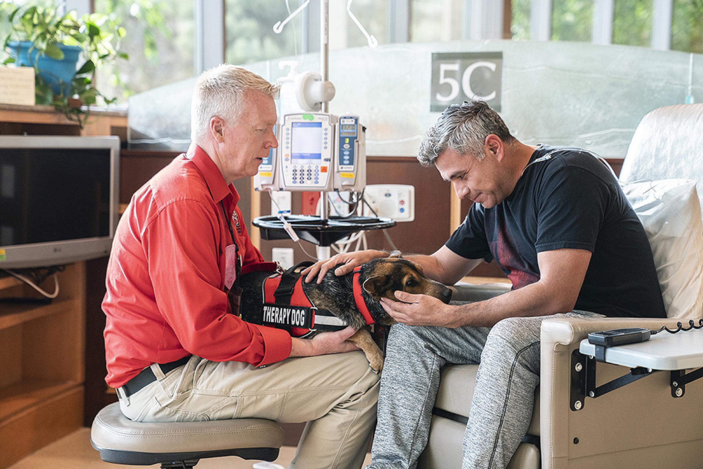 Jim Pehkonen and Luna sitting with a patient