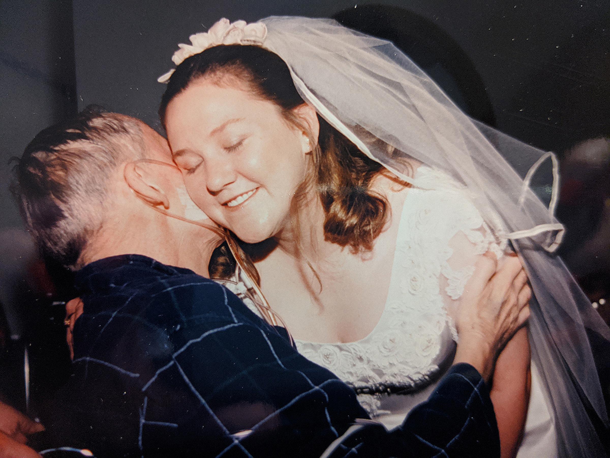 Karen Jensen embracing her dad at her wedding