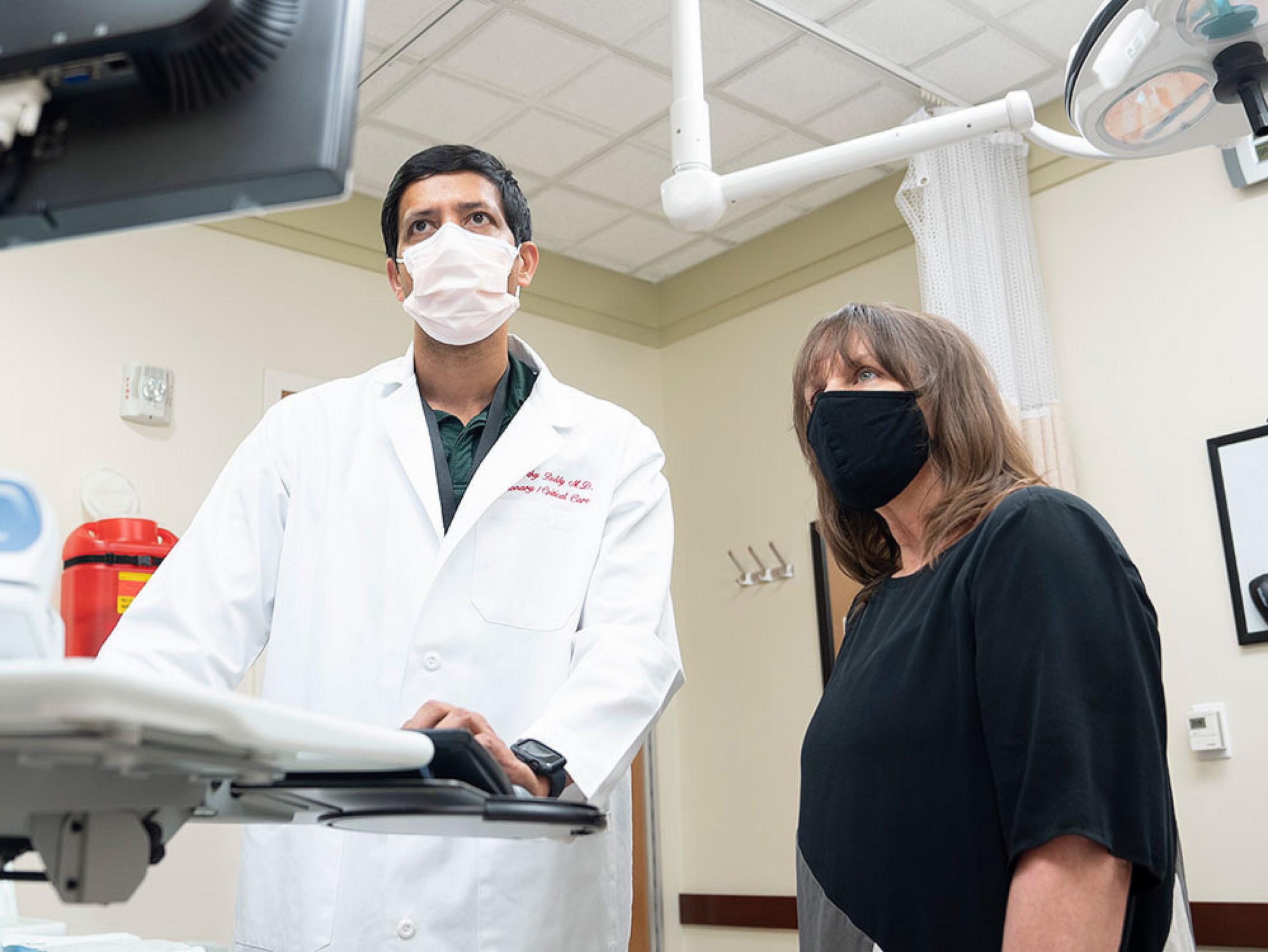Chakravarthy Reddy, MD and Lynette Phillips look at a computer monitor