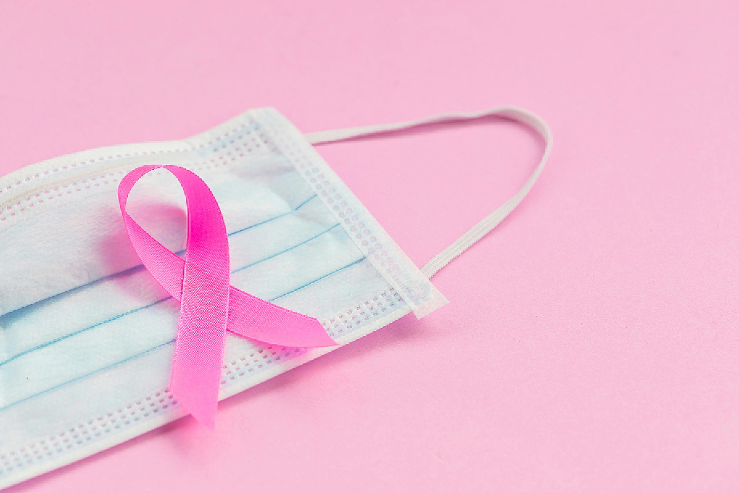 Pink ribbon on top of a surgical mask
