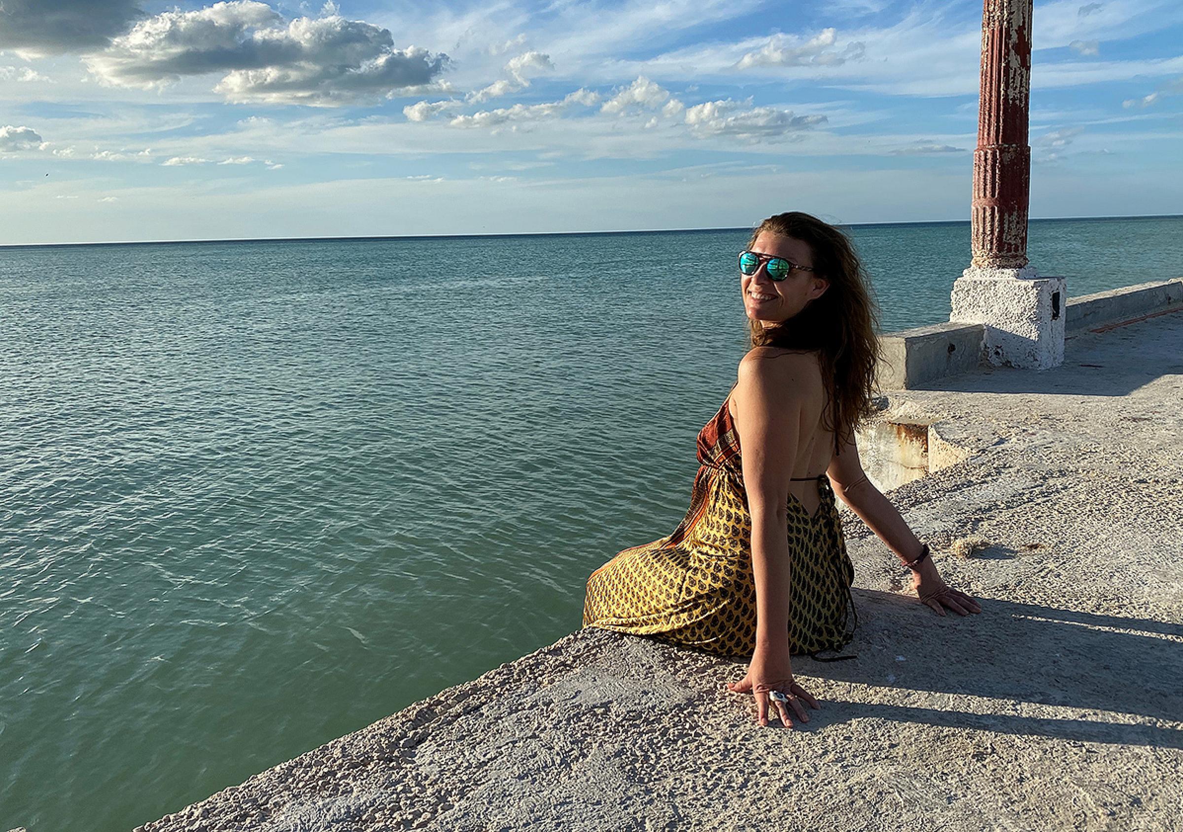 Mandy Murry sitting on the edge of pier over the ocean