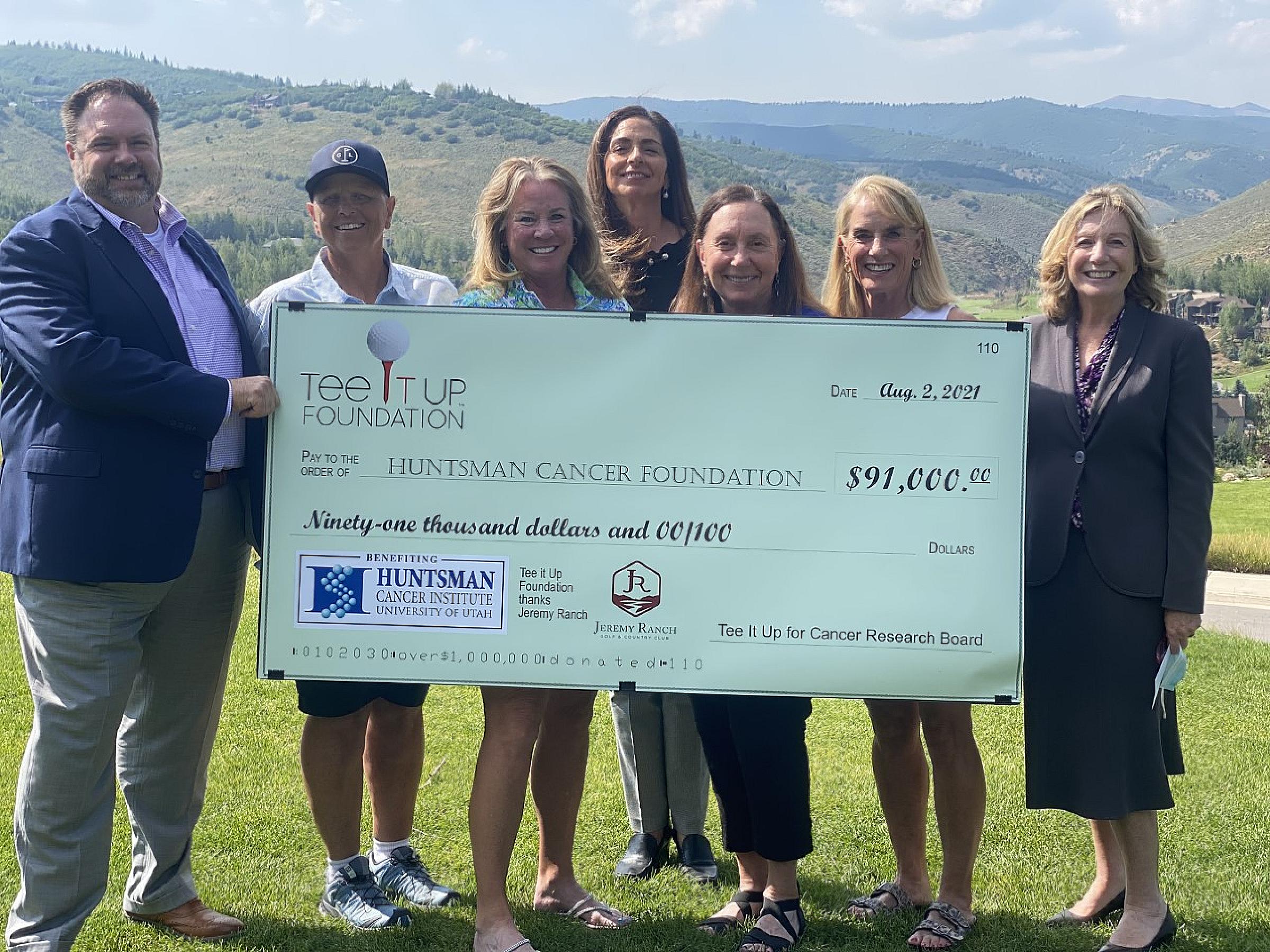 Brad Bishop (left) and Susan Sheehan (far right) receive a check from the Tee It Up Foundation