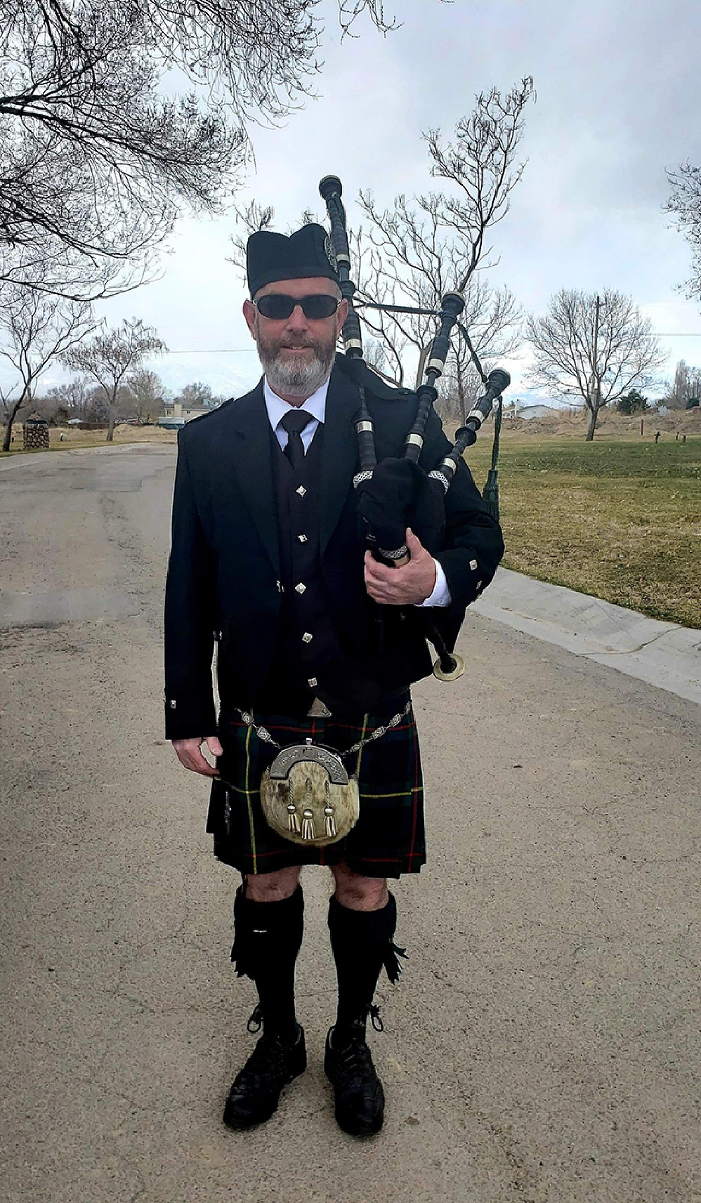 Doug Engle in Scottish regalia holding bagpipes