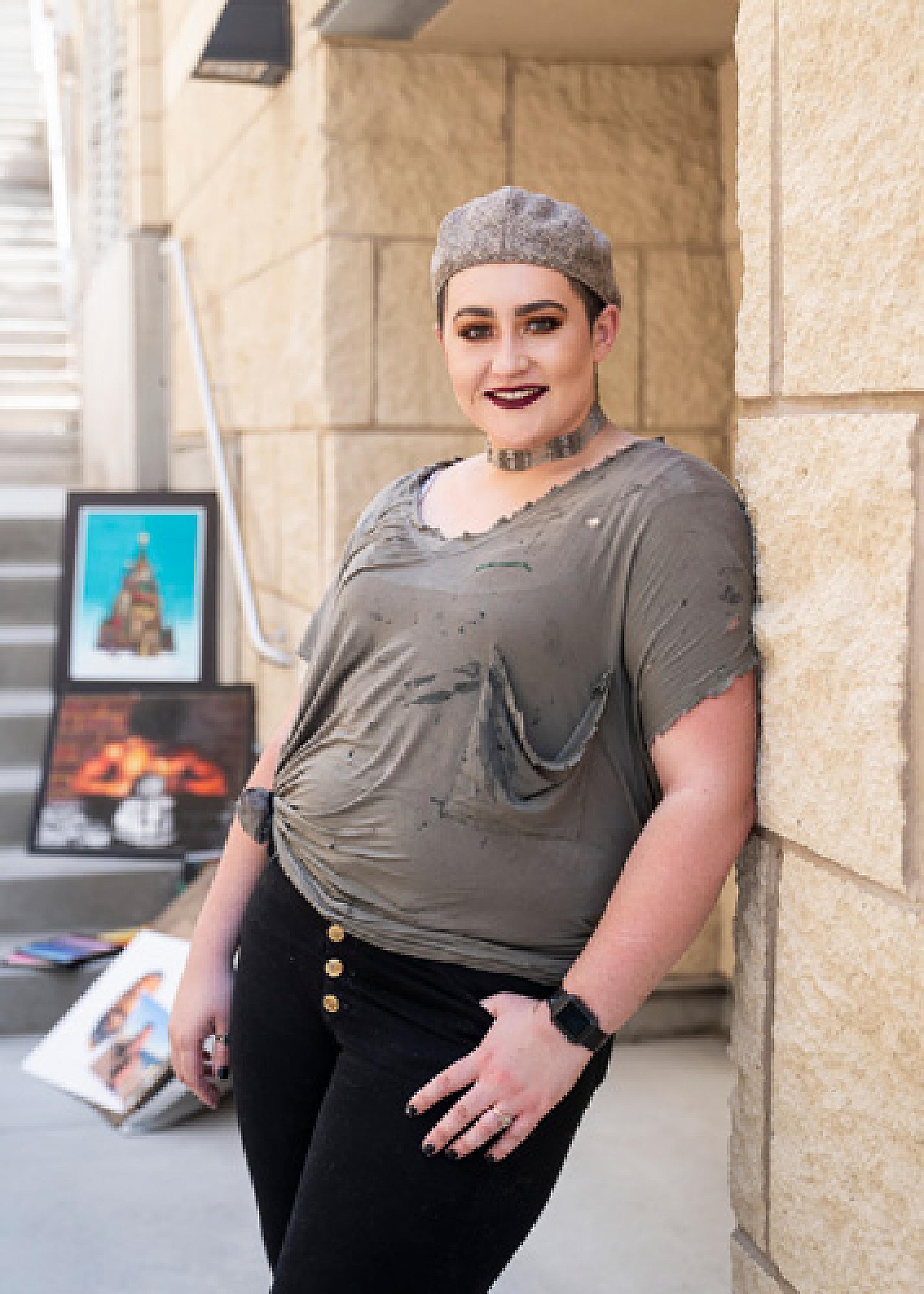 Taylor Lambert standing outside on stairs next to paintings