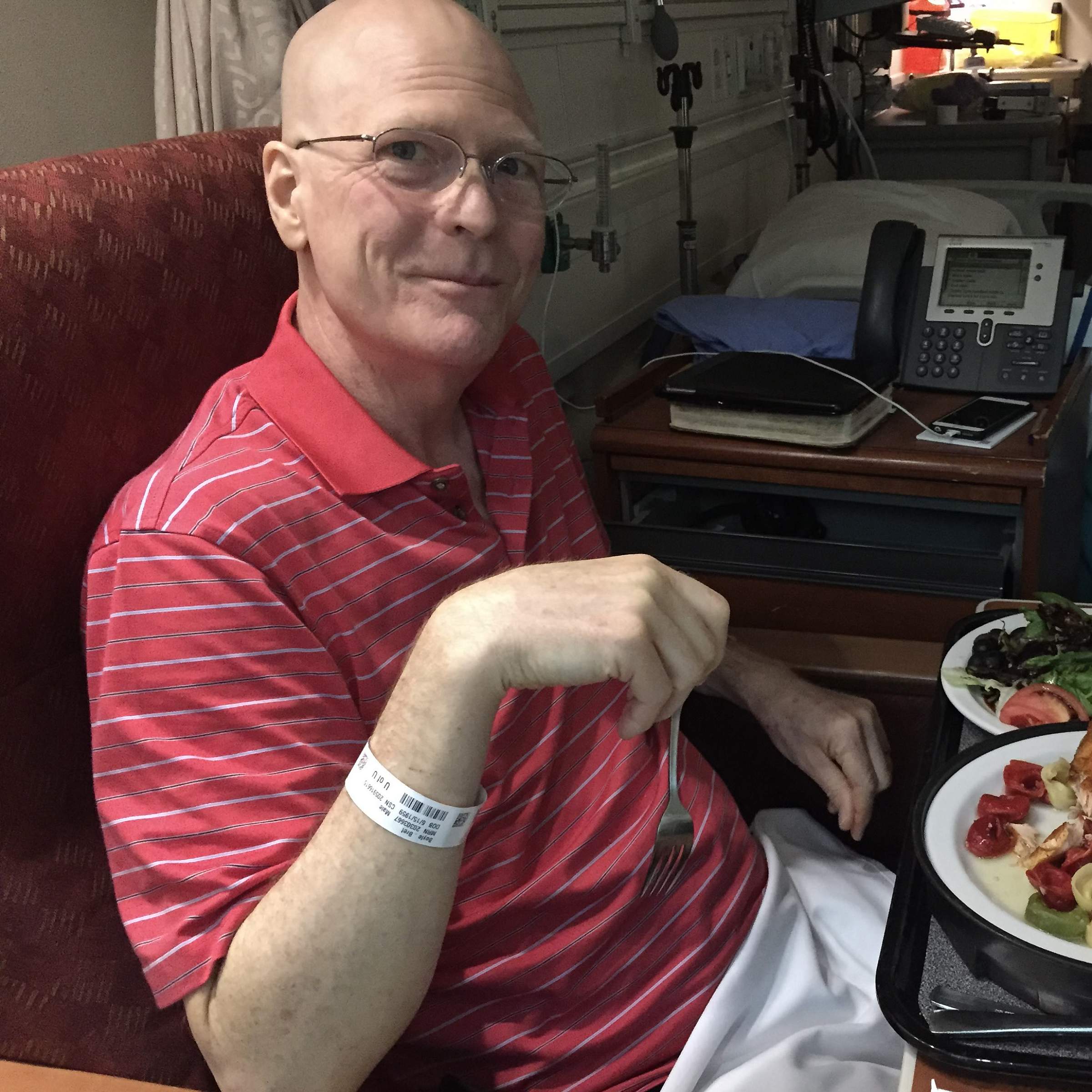 Bret Boyle sitting in a hospital room eating dinner