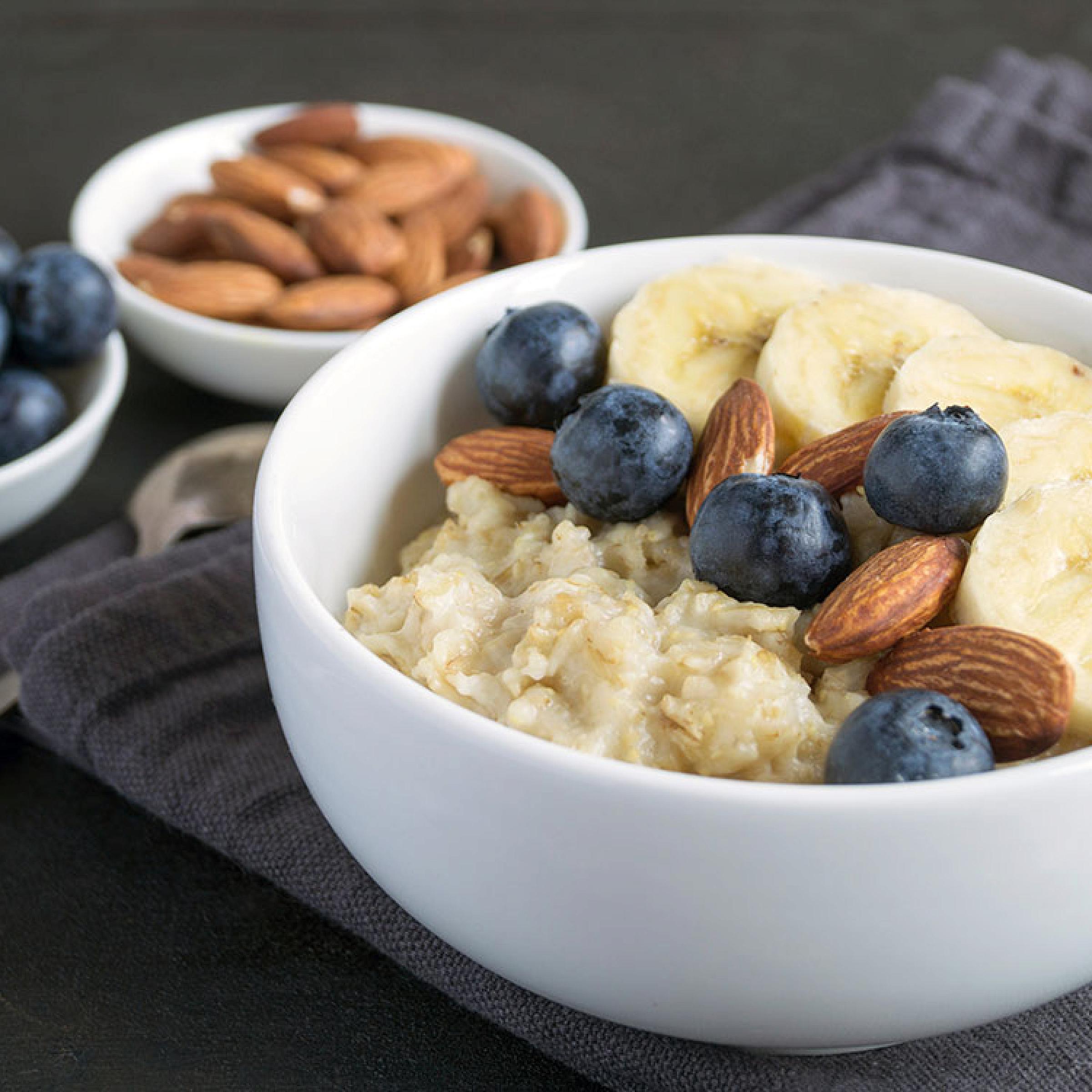 bowl of oatmeal, almonds, blueberries, and banana slices