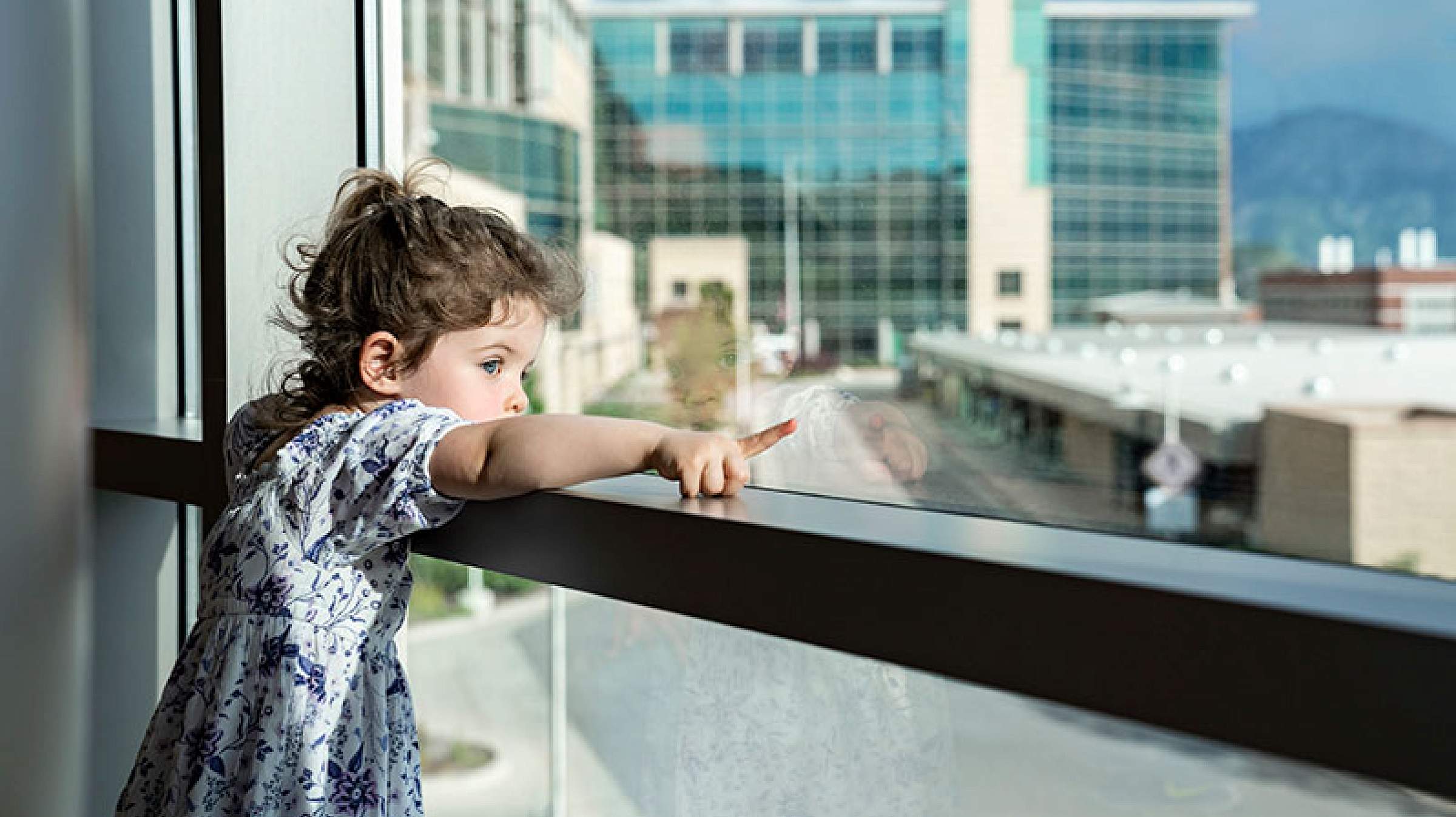 Toddler pointing out window of the hospital at Huntsman Cancer Institute
