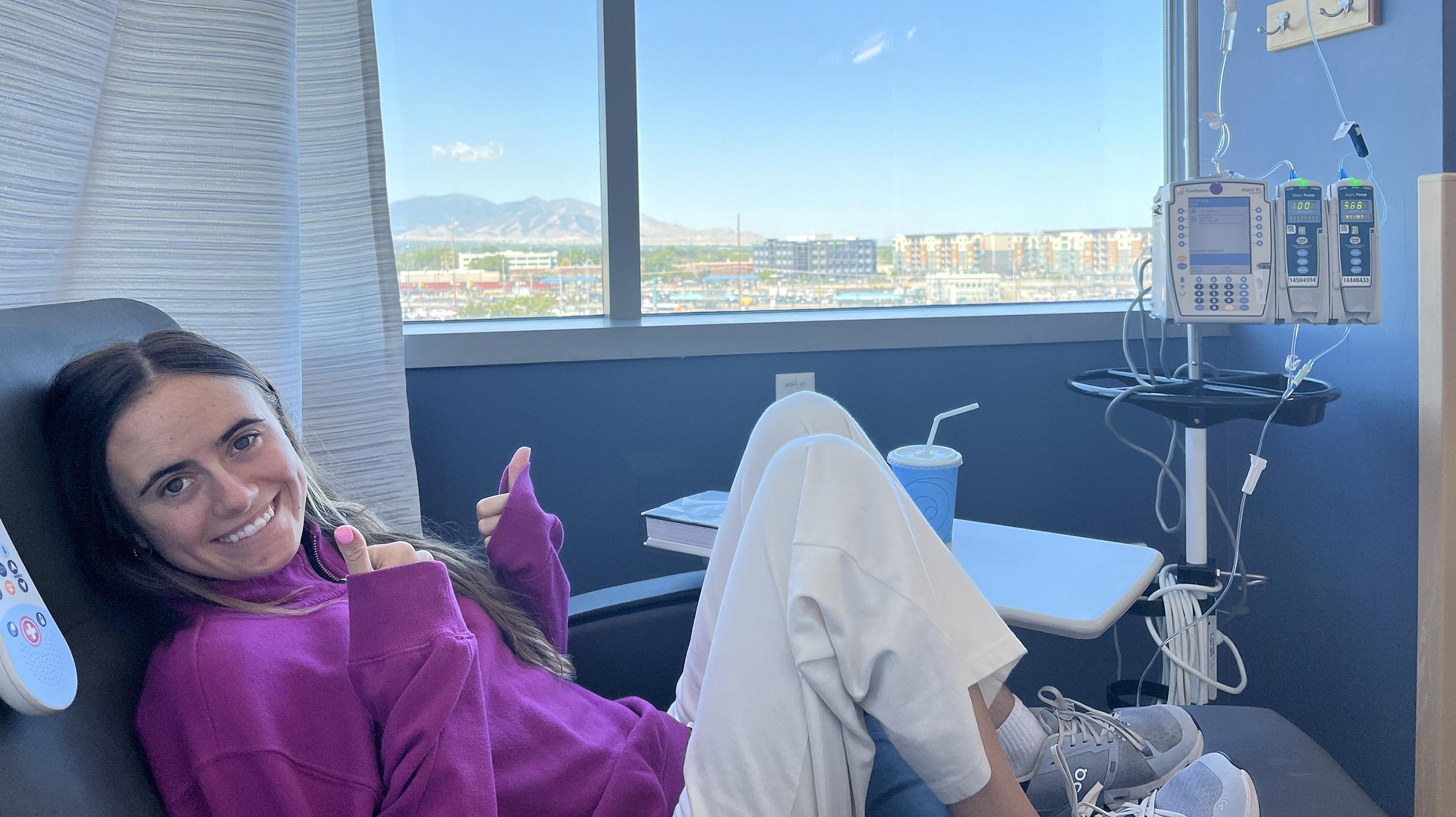 Brinlee Luster sitting next to a window and giving the camera two thumbs up