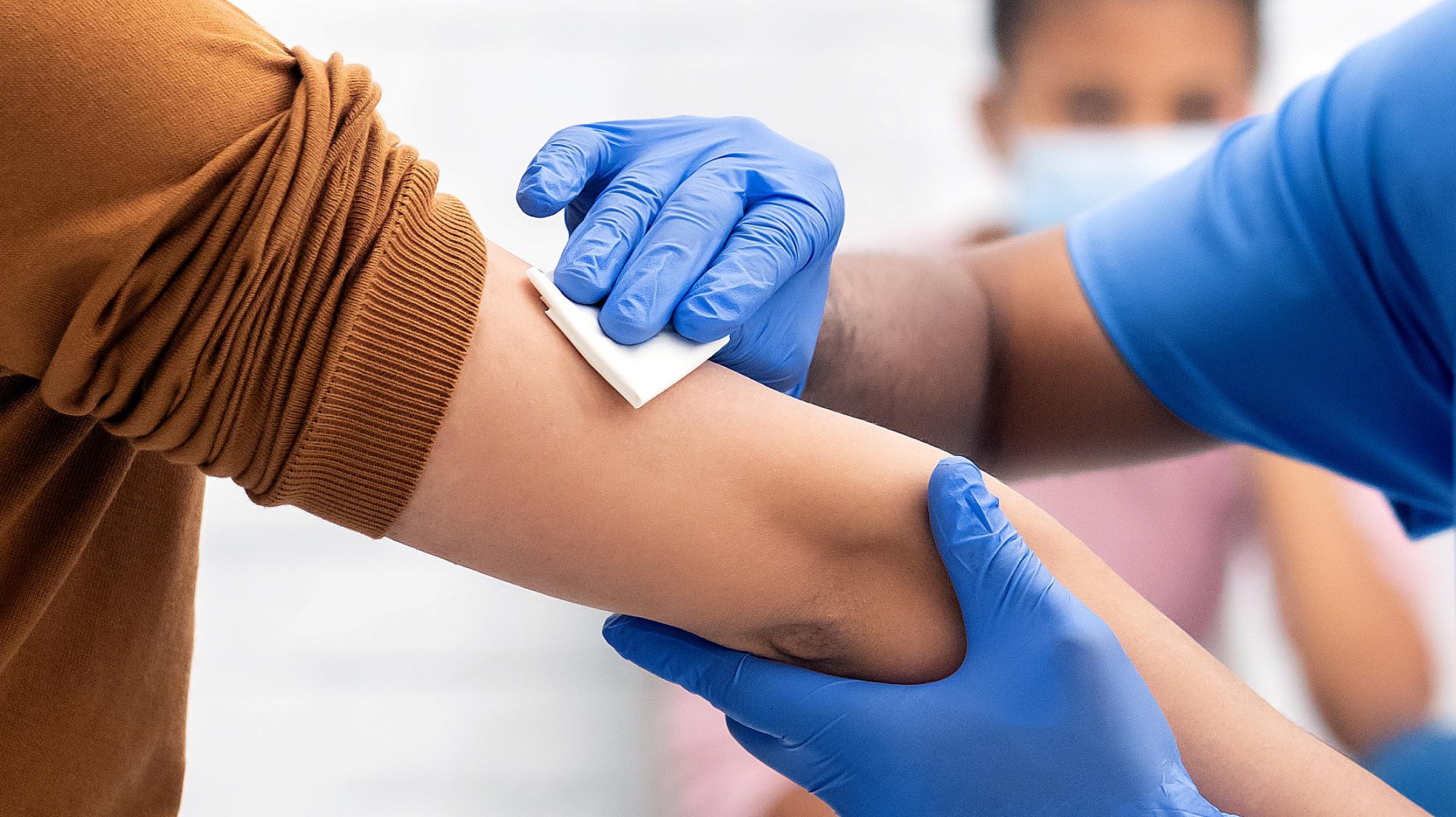 man receiving vaccine from nurse