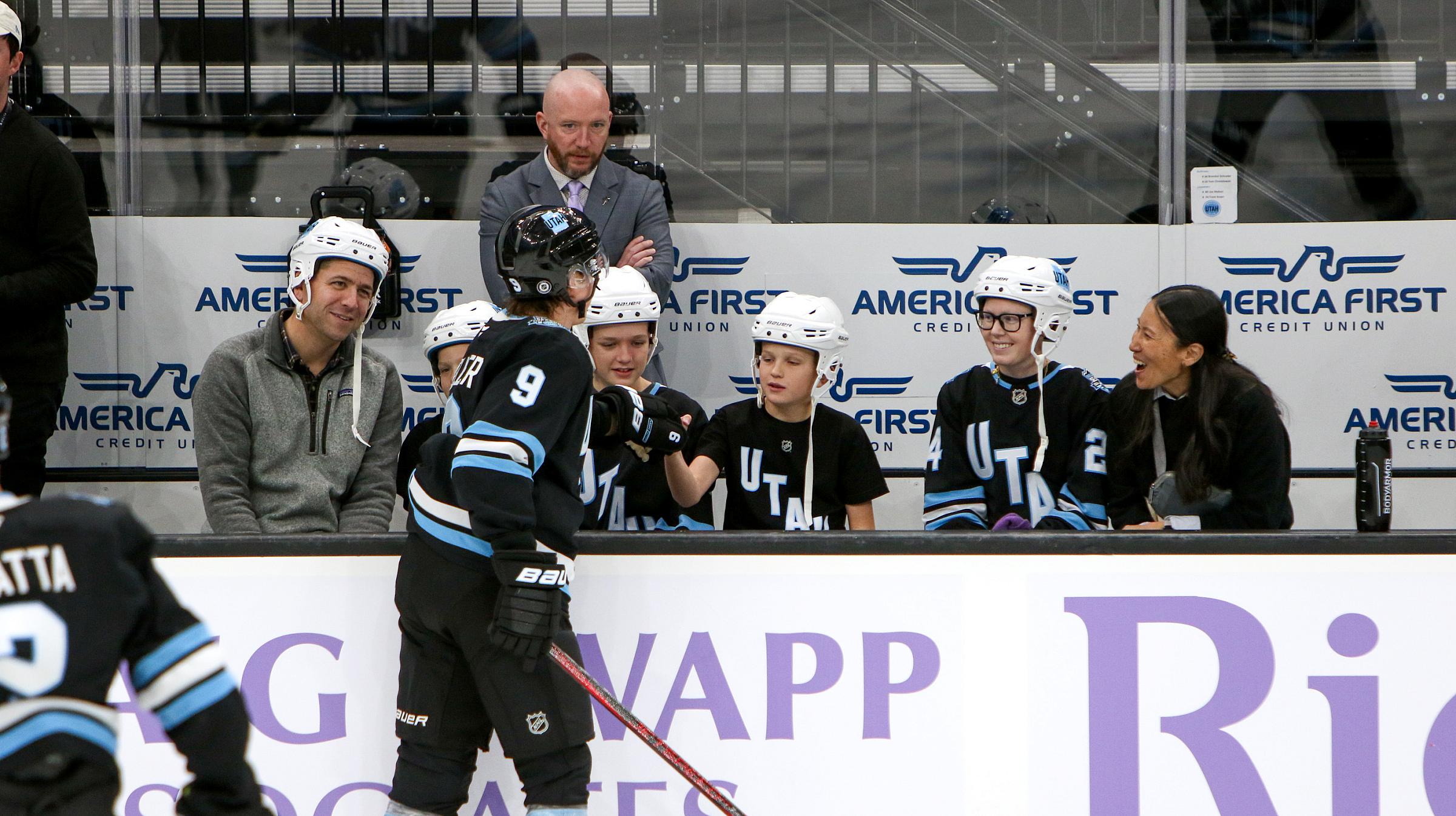 Patients with friends and family watching the warmups from the player's bench