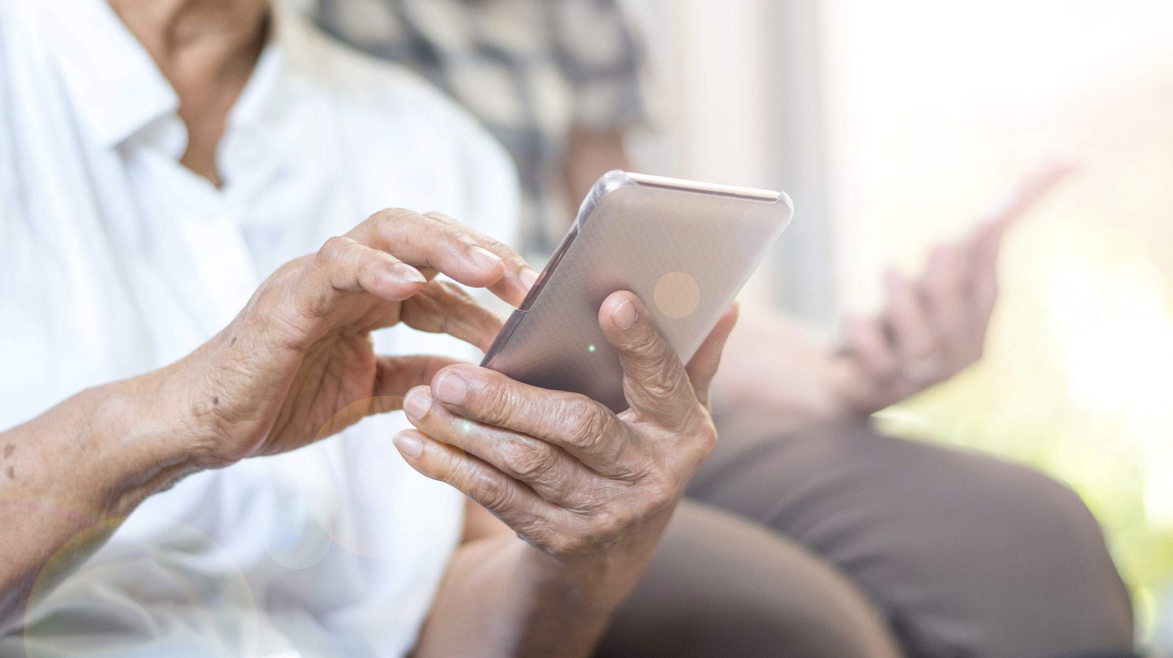 Close up of an older woman holding a cell phone