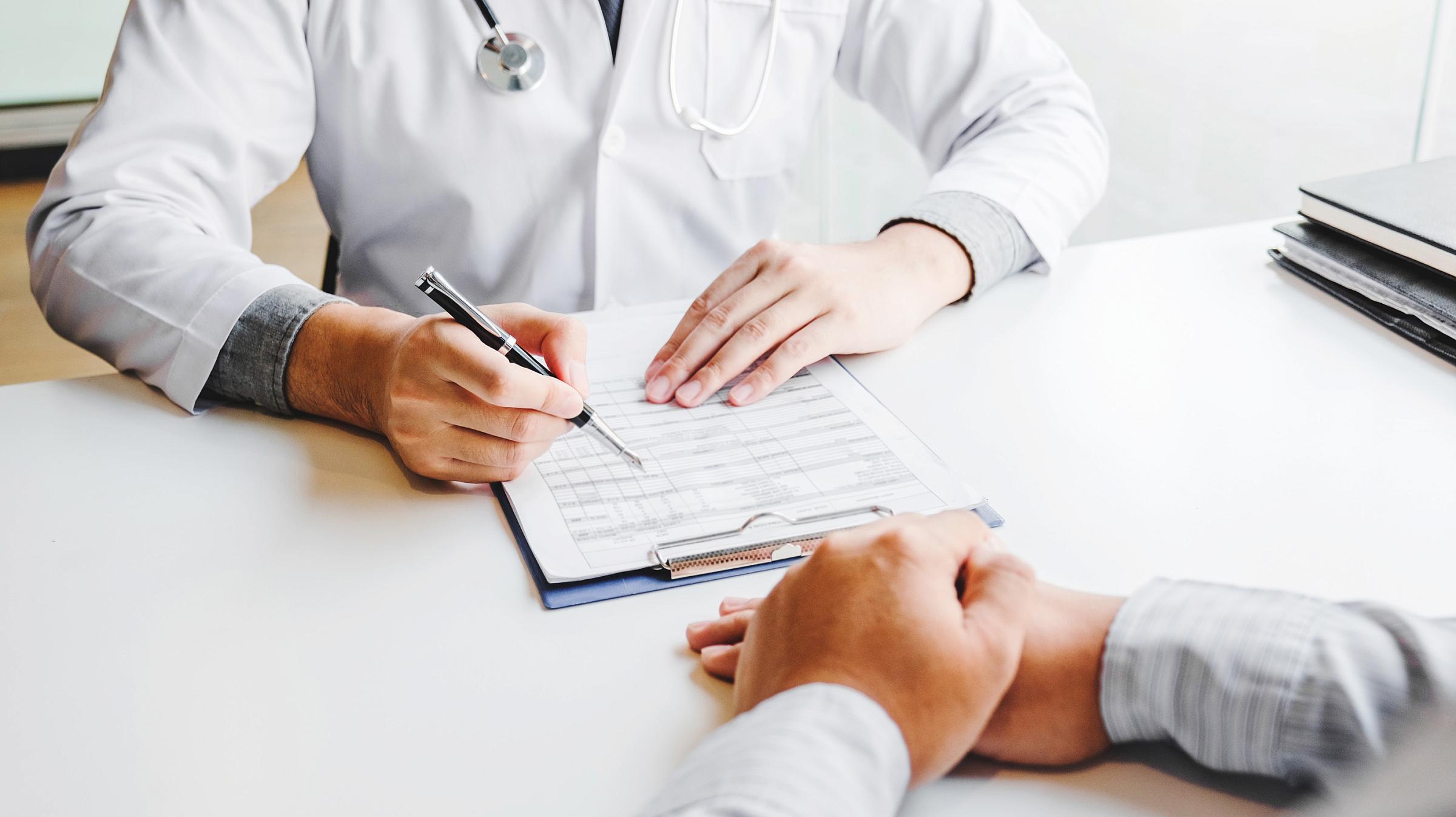 Provider sitting across from patient and looking at a clipboard