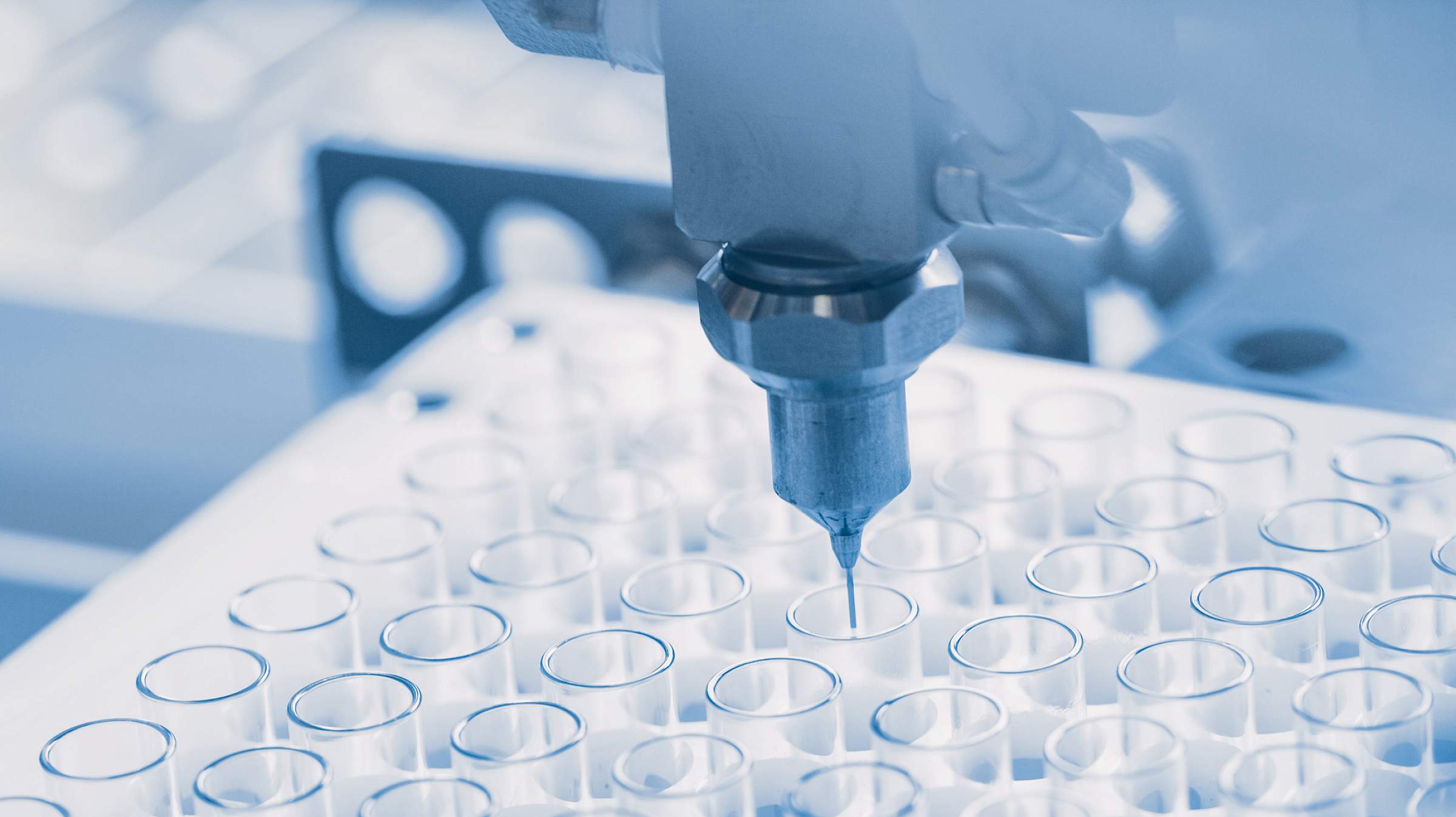 Machine dropper over tray of test tubes