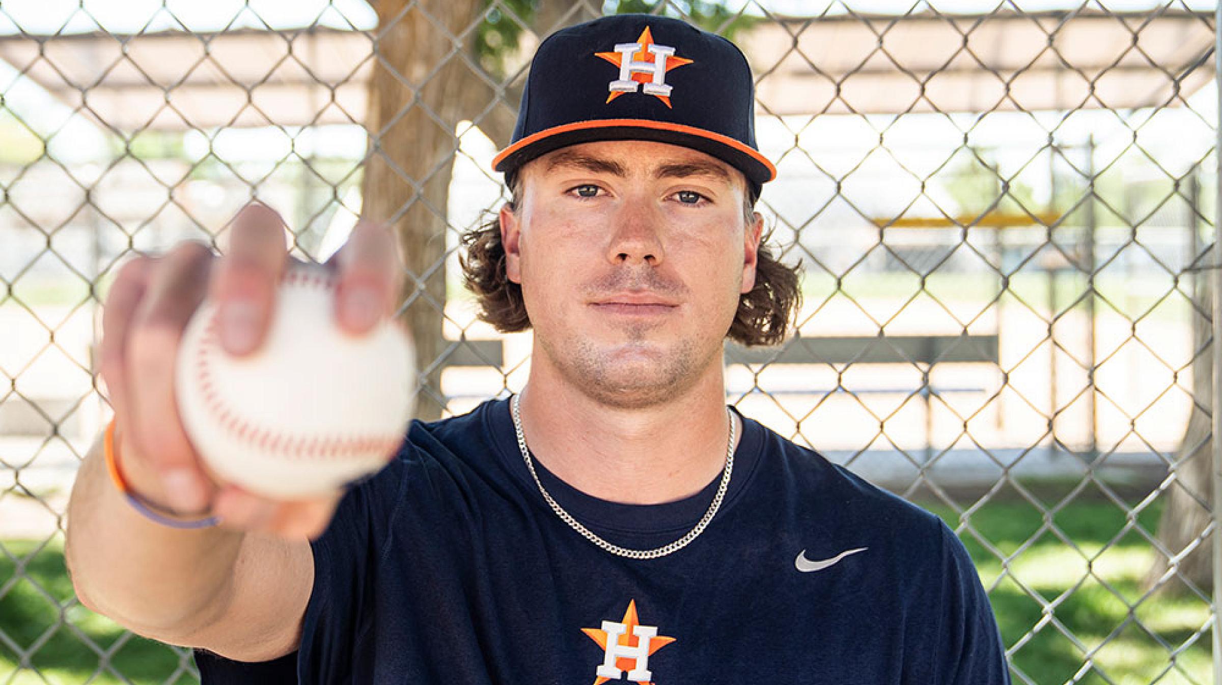 Adam Whitt holds a baseball