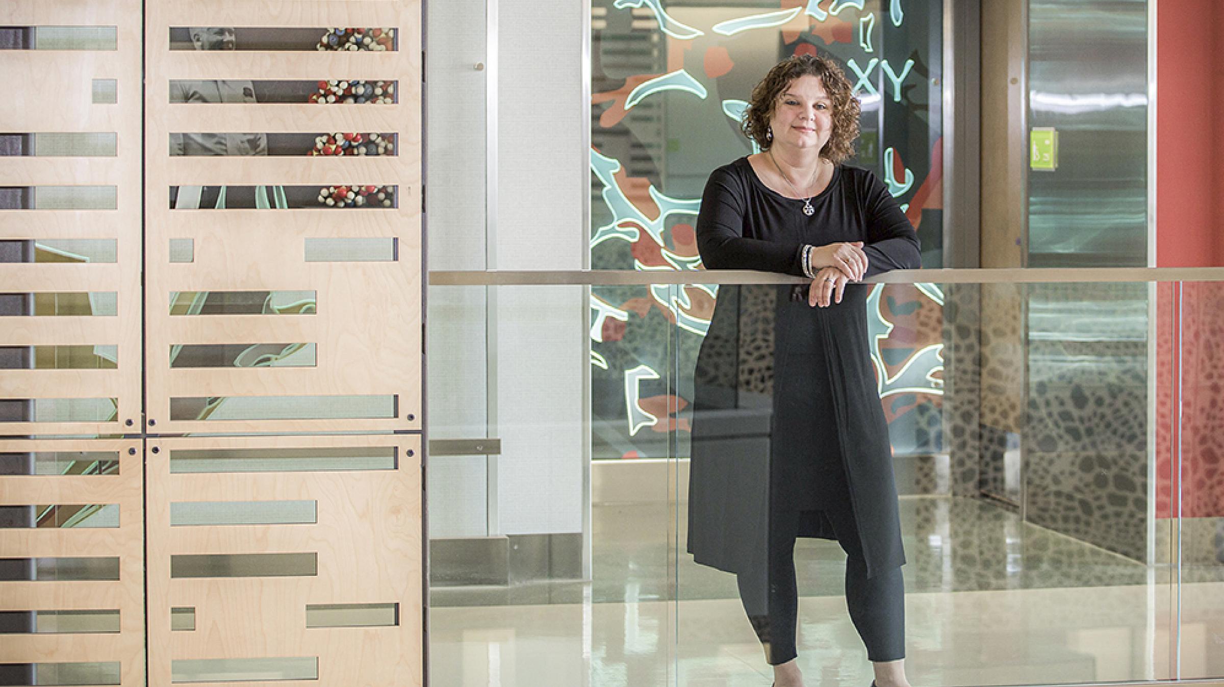 Deanna Kepka Standing Behind Glass Railing