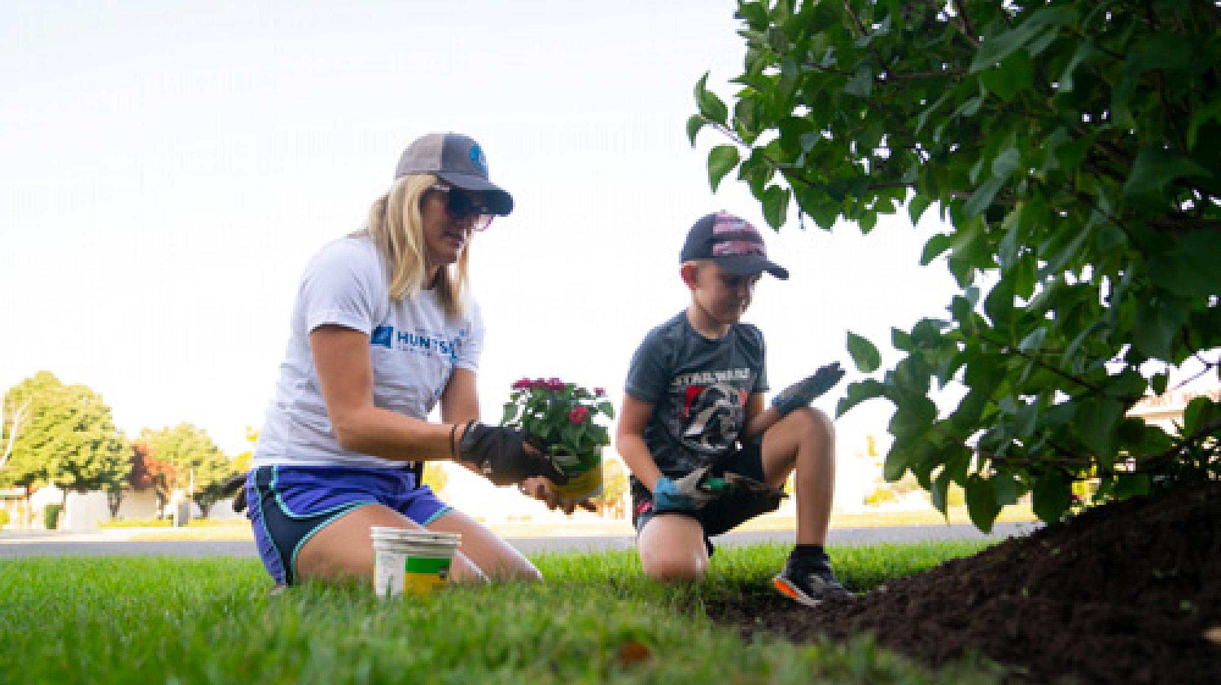Ashlee Harrison planting flowers with her son outside