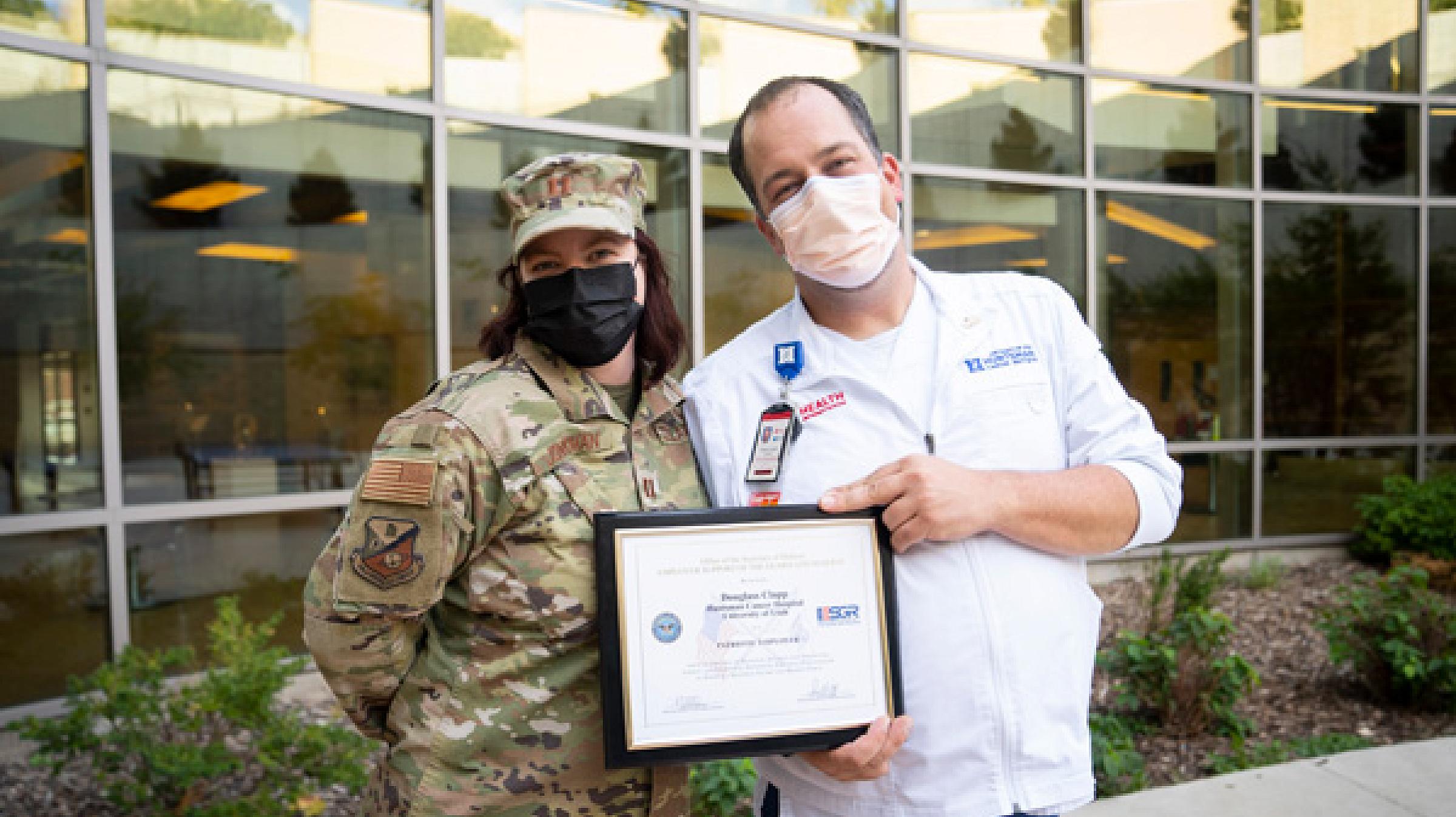 Captain Christy Jonkman, RN (left) and Douglass Clapp, RN (right) pose with the award