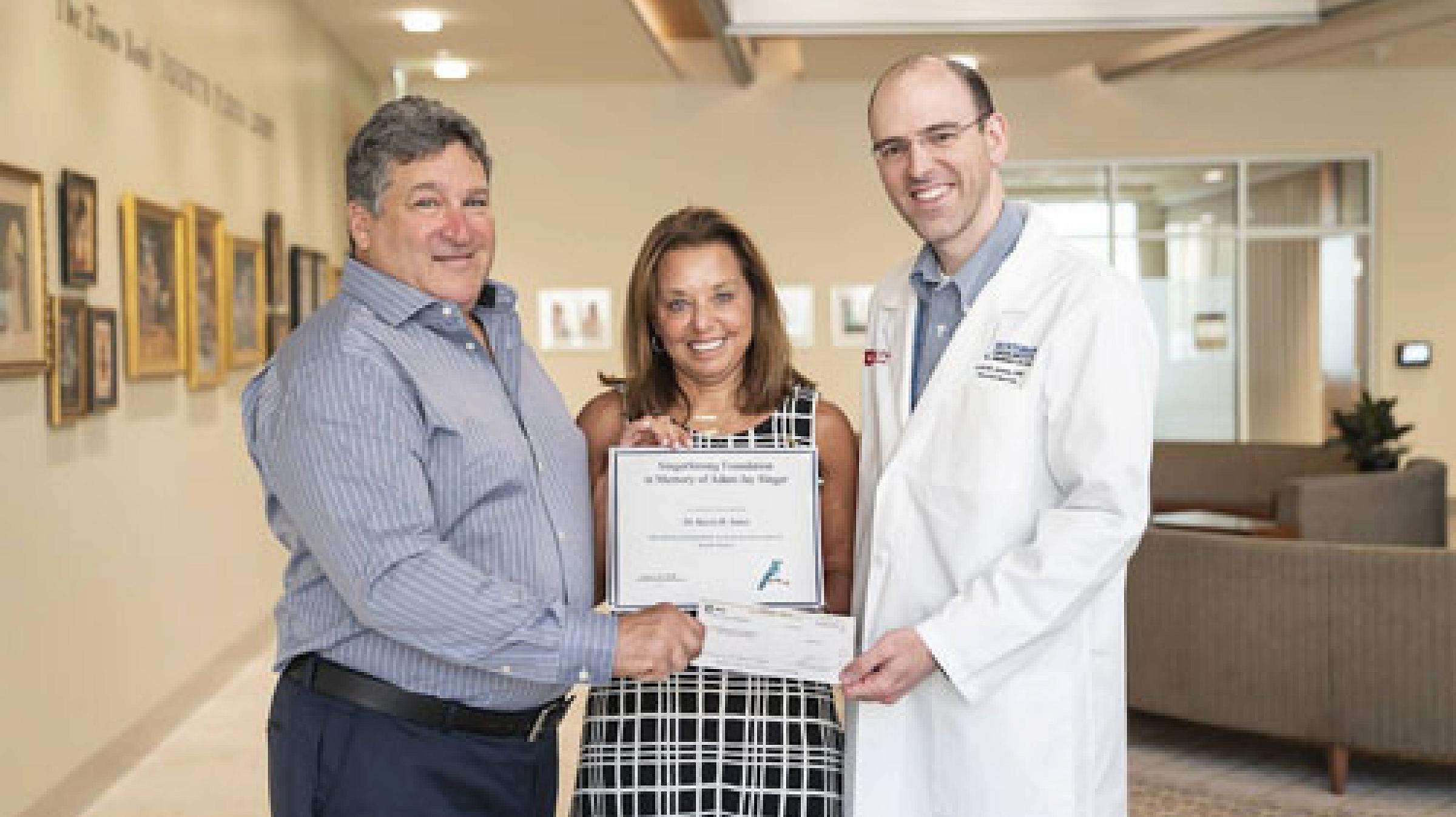 Karen and David Singer presenting donation check to Dr. Jones