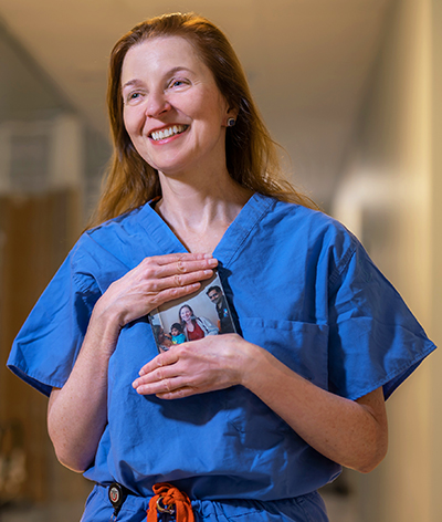 Mary Elizabeth Hartnett, MD, holds a favorite photo of Aidan, a youngster from Trinidad and Tobago she has treated for years for retinopathy of prematurity.