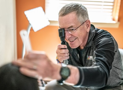 Robert O. Hoffman, MD, head of Moran’s Division of Pediatric Ophthalmology and Eye Muscle Disorders, examines a patient during the Monument Valley clinic.