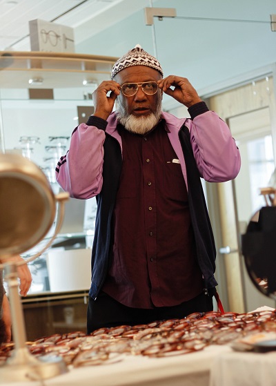 A patient tries on eyeglasses at a past Moran Eye Center Refugee Eye Care Clinic.