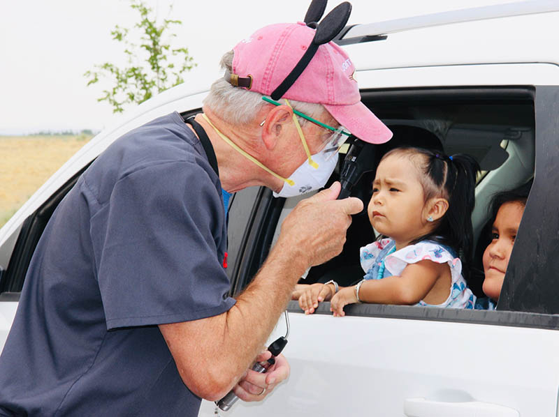 Pediatric specialist Robert Hoffman, MD, asks questions to determine whether children were experiencing vision issues. If so, he gave them a thorough eye exam in the clinic.