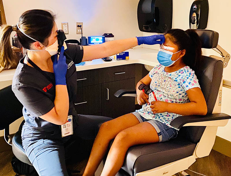 Katherine Hu, MD, examines a child during the Teddy Bear Clinic Aug. 21 in Blanding.