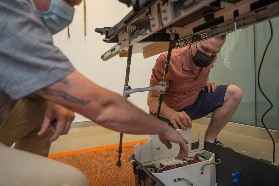 Design team members demonstrate the portable unit’s three lithium-polymer batteries, enough to charge all of Moran’s commonly used eye exam equipment at least once during a workday.