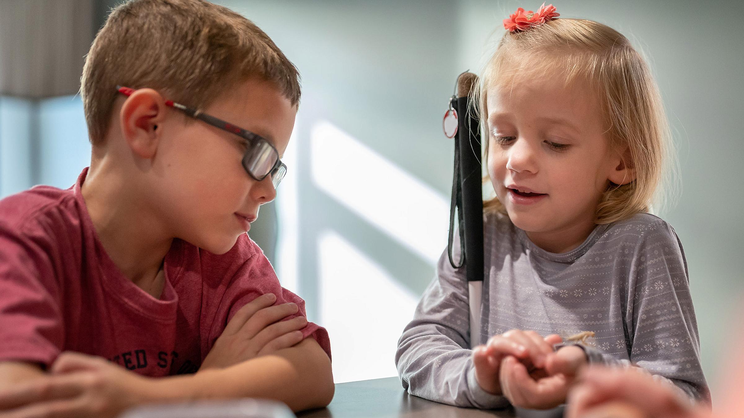Andrew, 9, waits his turn while Maeve, 5, experiences the feeling of a white praying mantis on her wrist.
