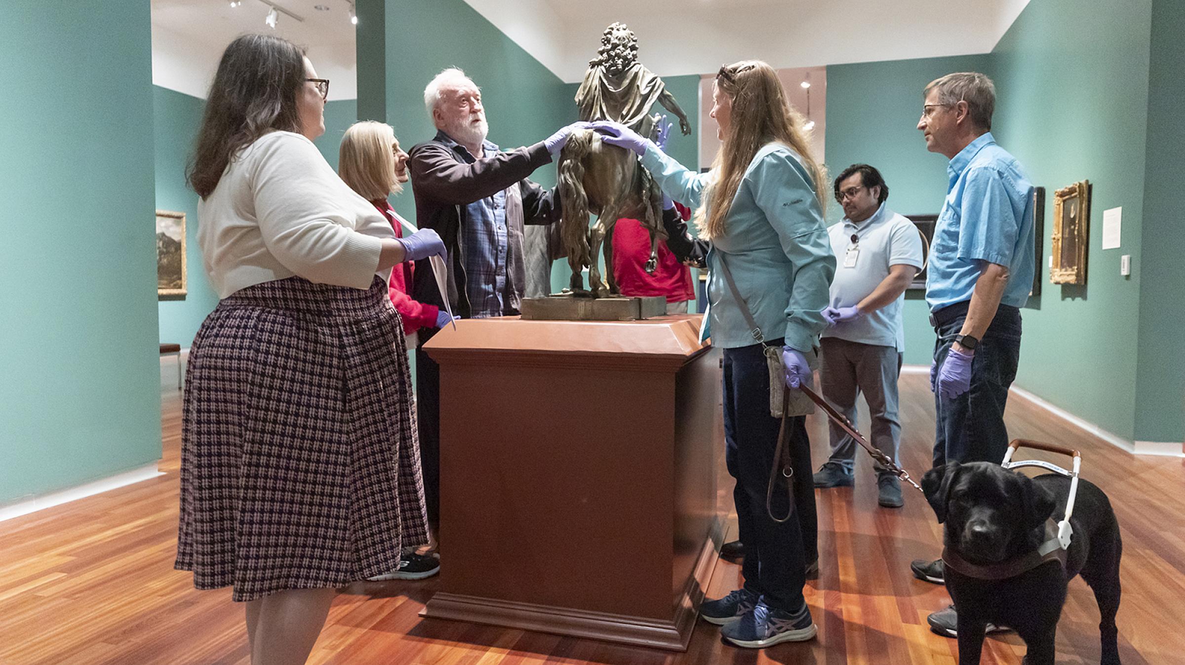 Participants in a Moran Eye Center Patient Support Program “Touch Tour” at the Utah Museum of Fine Arts experience a bronze statue from the 1700s.