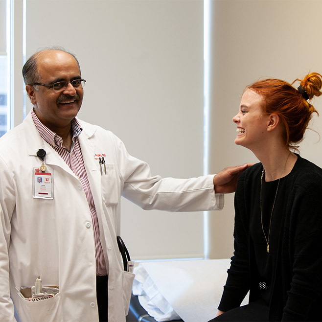 U of U Health epilepsy specialist, Dr. Arain smiles with his patient in the exam room