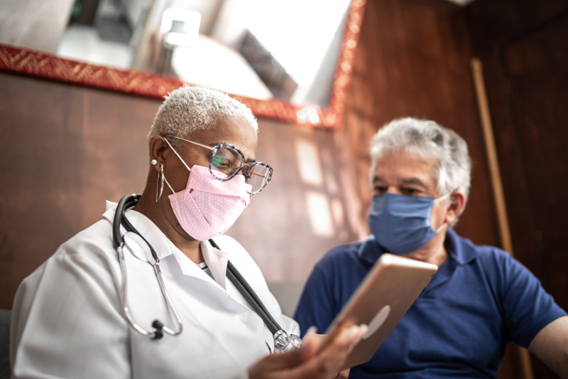 doctor reading medical chart with patient