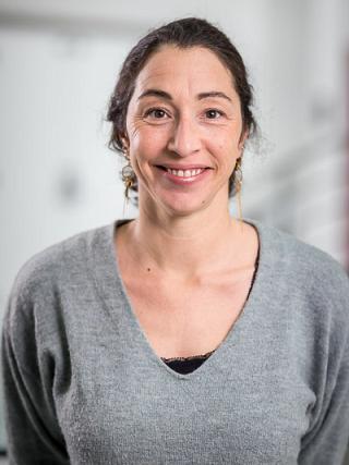 Profile photo of a woman with light skin and dark hair smiling at the camera.