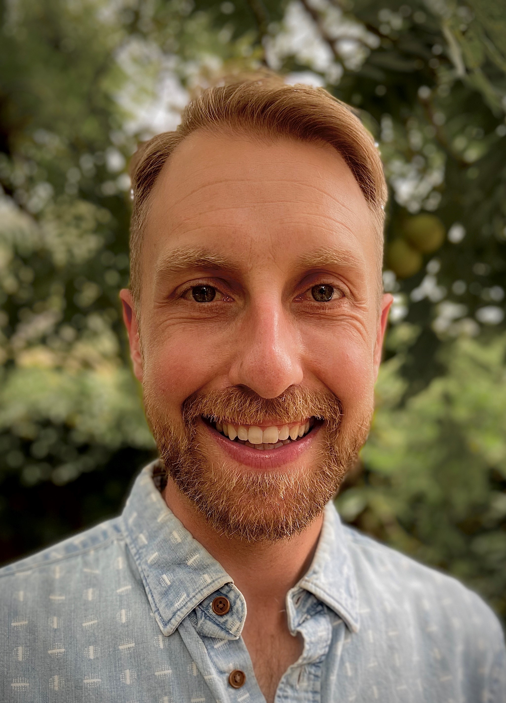 Profile photo of a man with light skin and blond hair smiling at the camera.