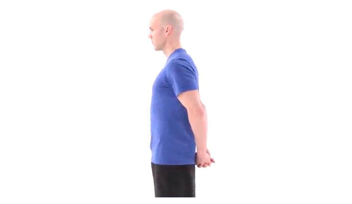 Person with their hands behind their back and fingers interlocked