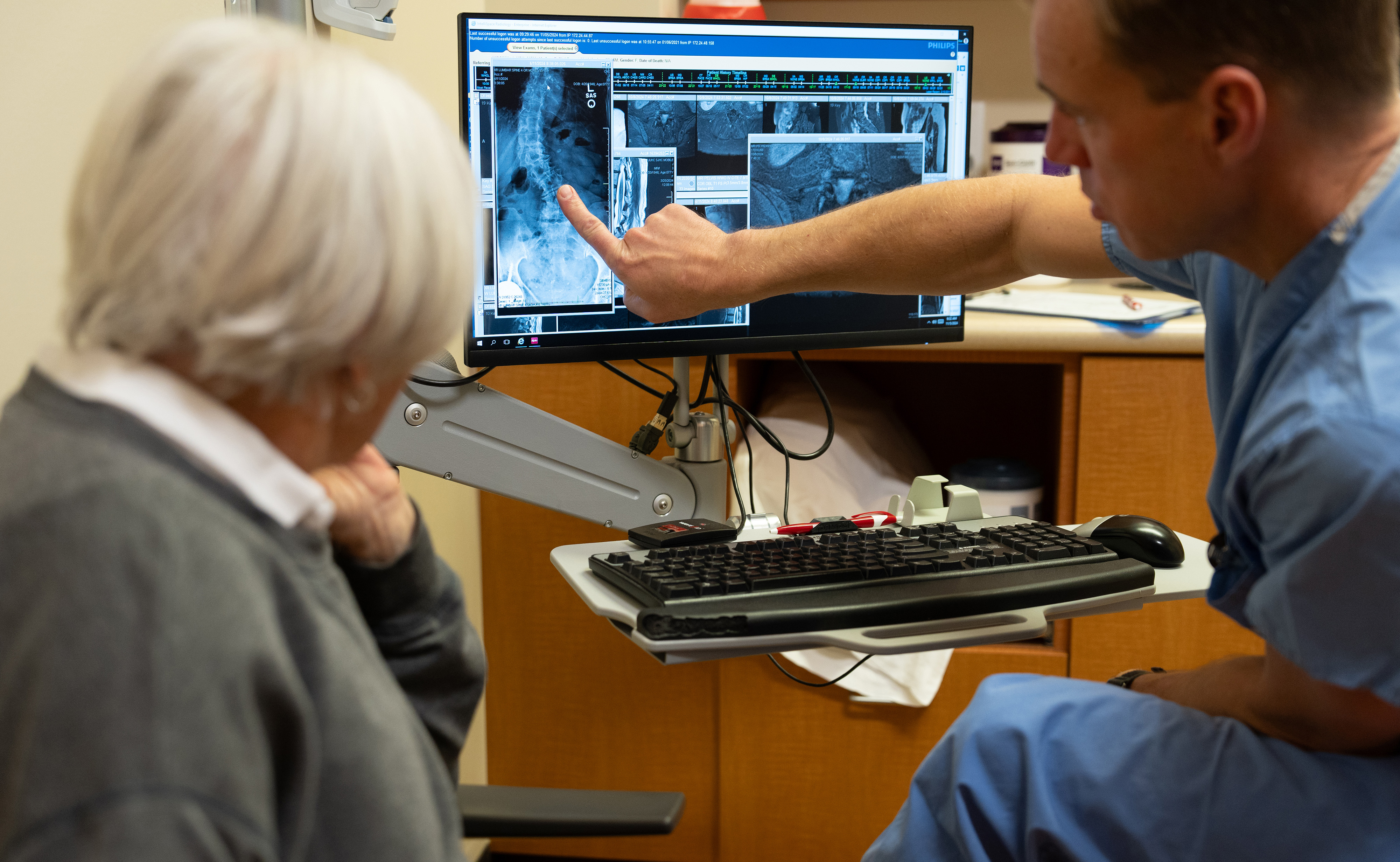 U of U Health neurosurgeon discusses spine X-rays with patient