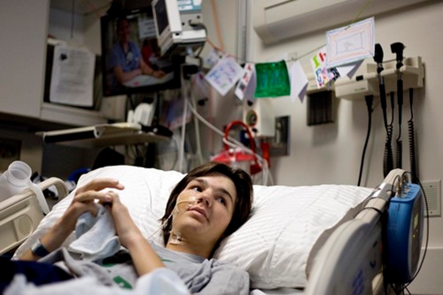Patient Hank Shipman at a younger age lying in his hospital bed looking up. 
