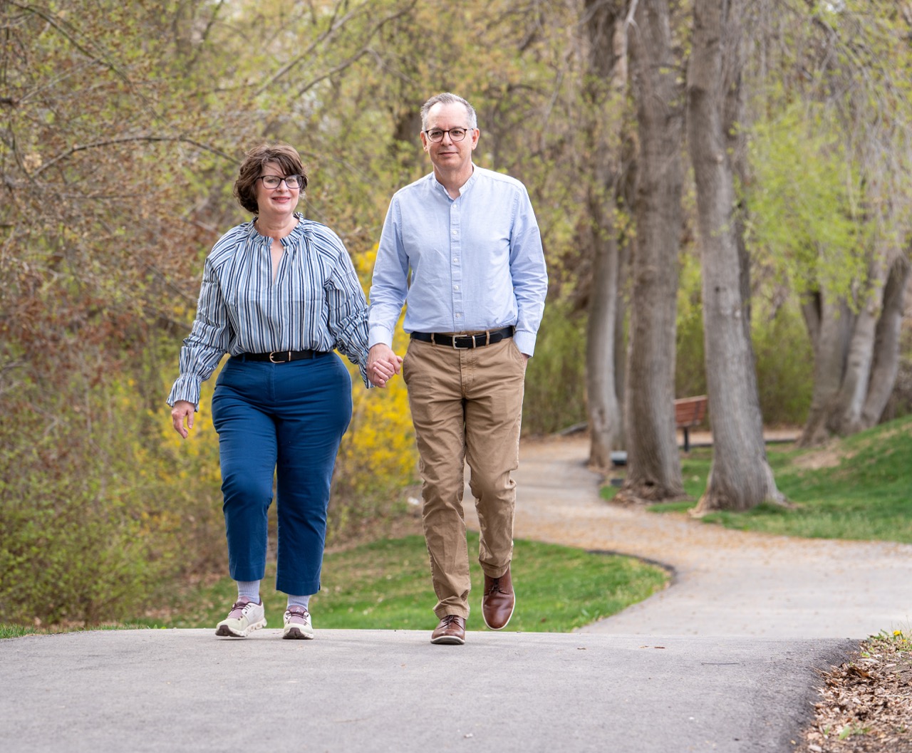 Tracy Zappala walking through a park hand-in-hand with her husband, symbolizing her recovery and renewed quality of life after brain surgery