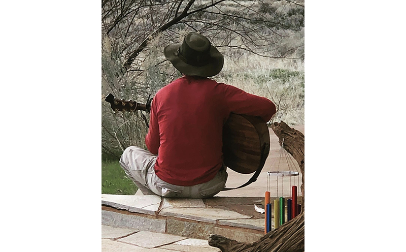 Hank playing his guitar in the desert