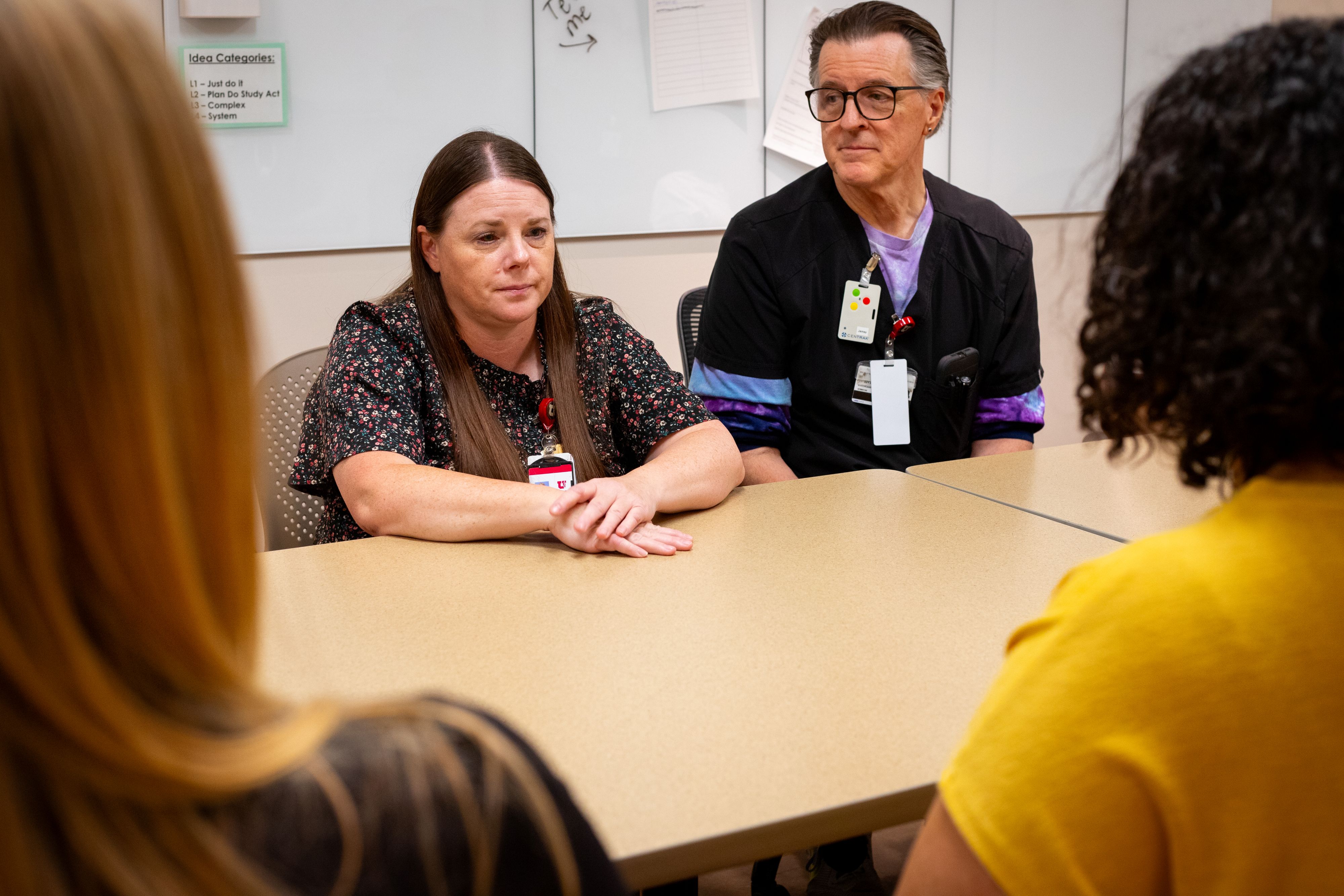 Marci listens to team members as they engage in discourse about resilience and well-being