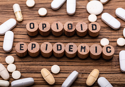 Opioid Epidemic in block letters surrounded by pills