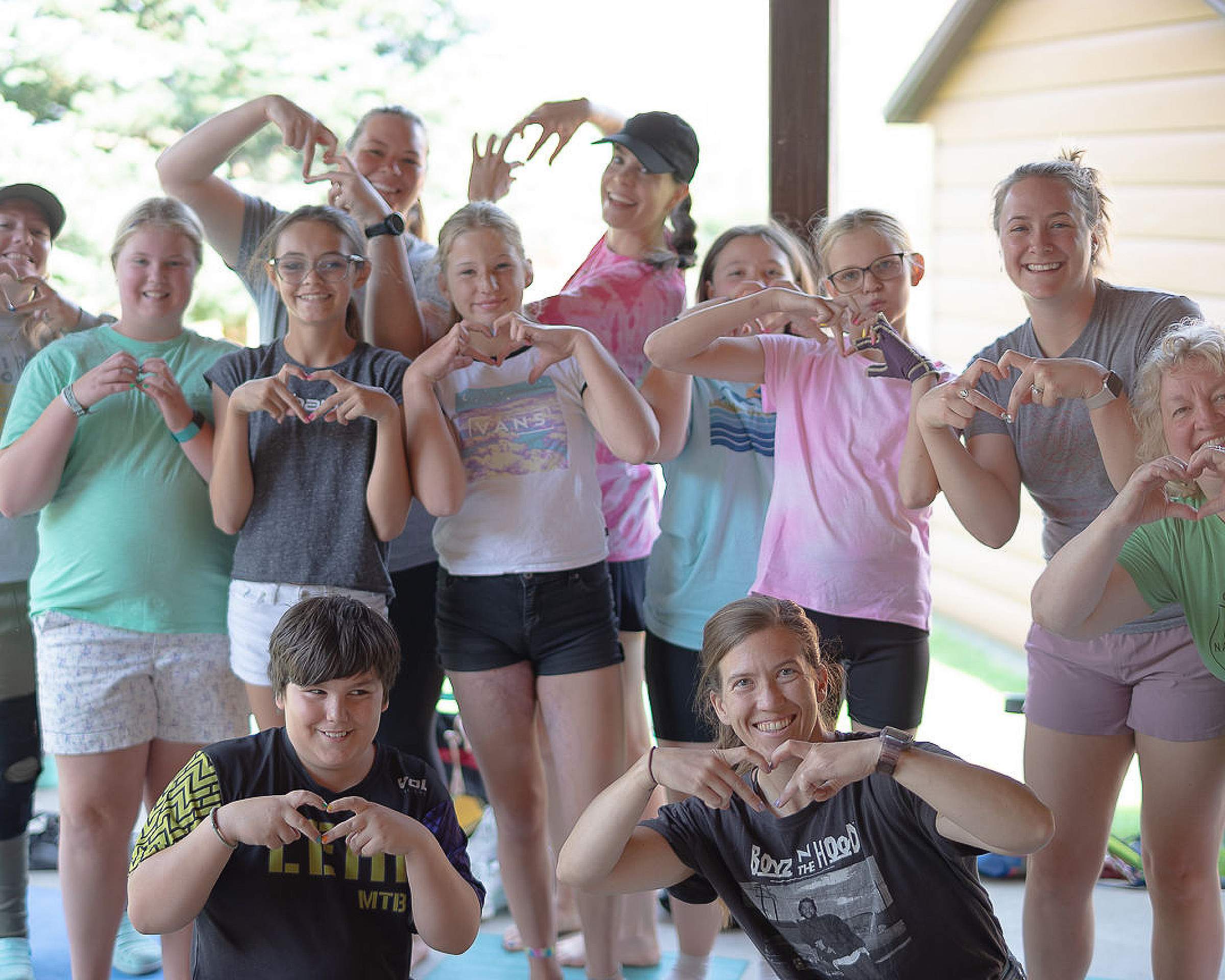 Camp Nah Nah Mah attendees make heart shapes with their fingers