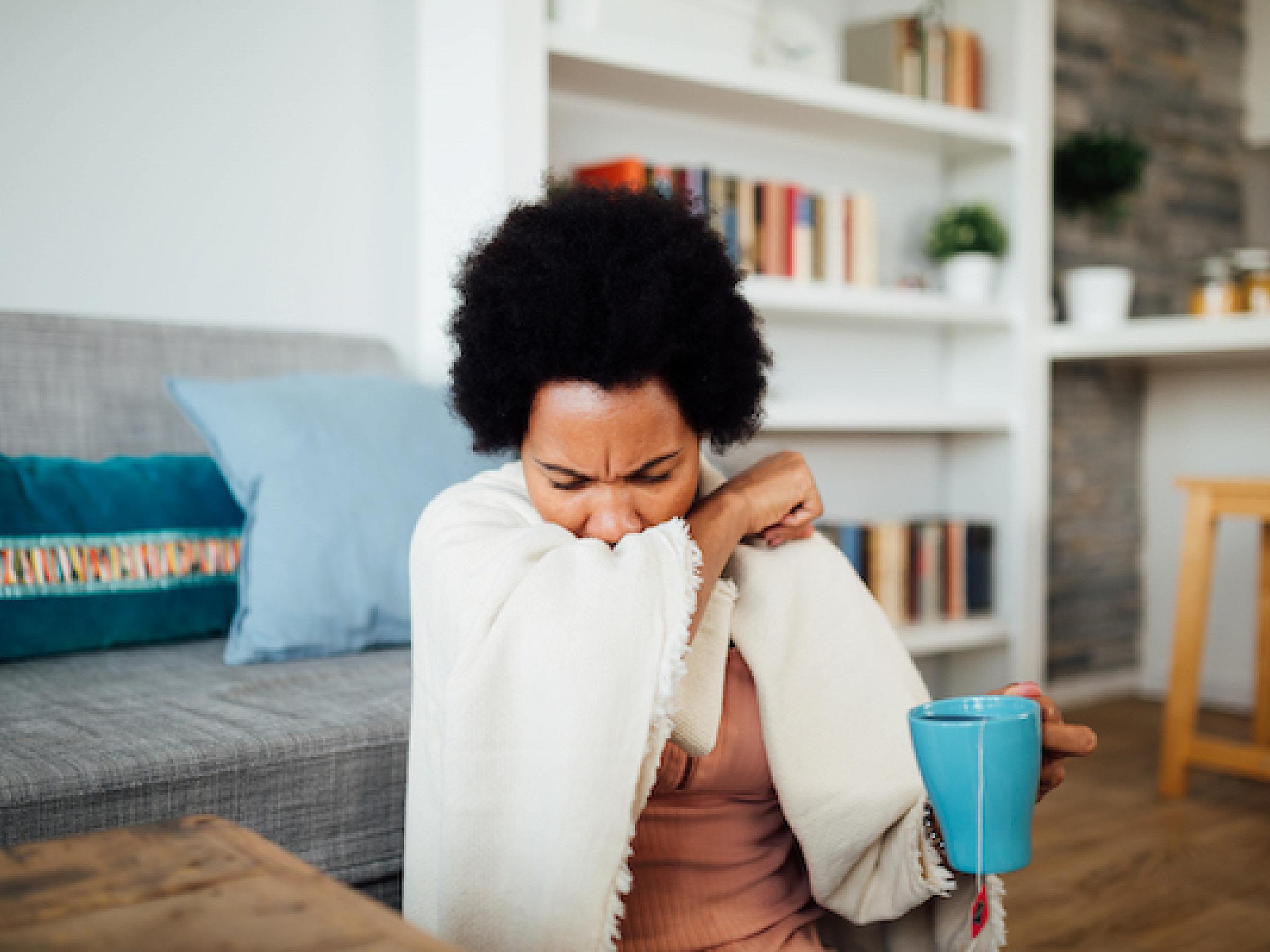Woman coughing into elbow